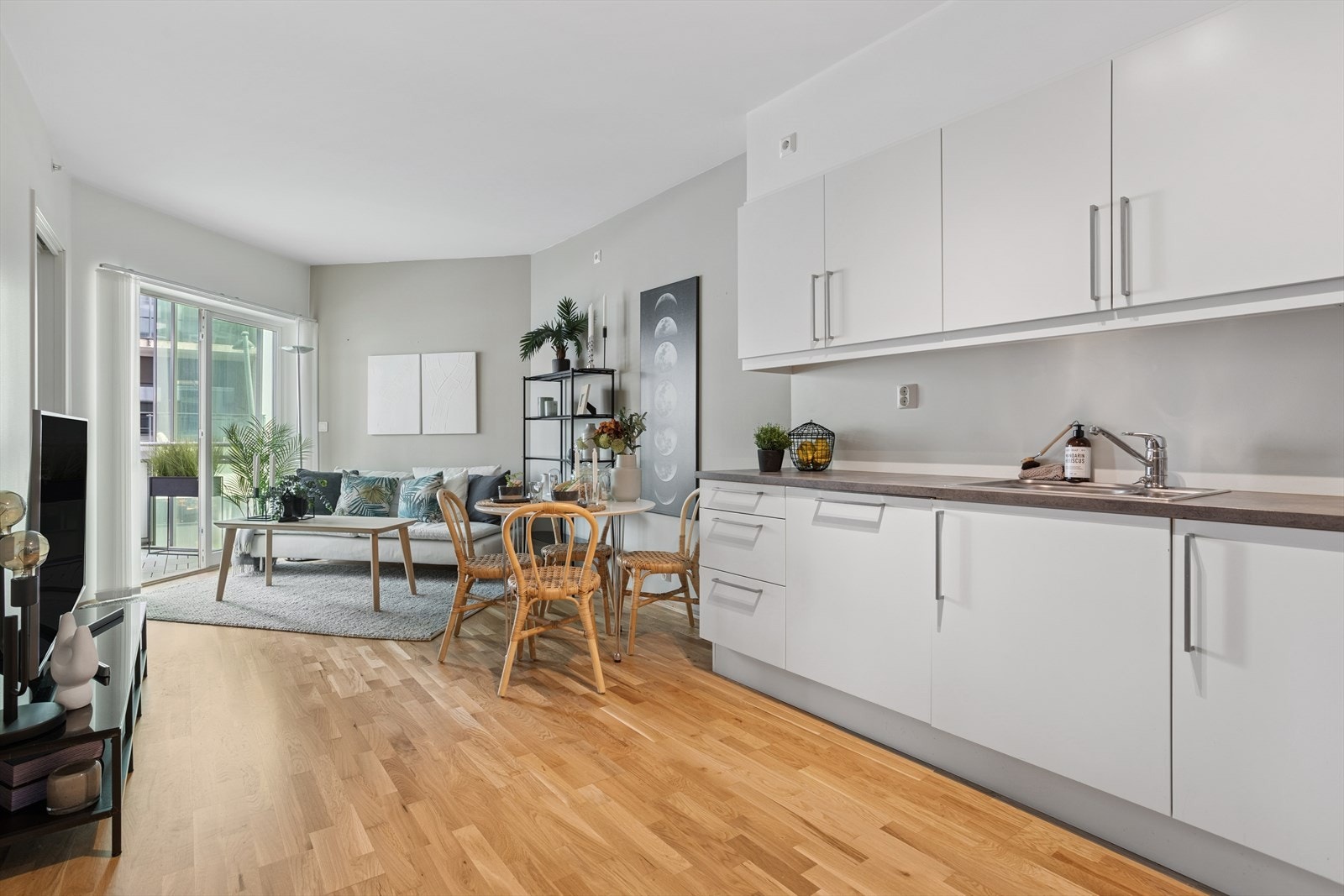 Lyst og funksjonelt kjøkken med plass til et lite spisebord og balansert ventilasjon. Galleribilde