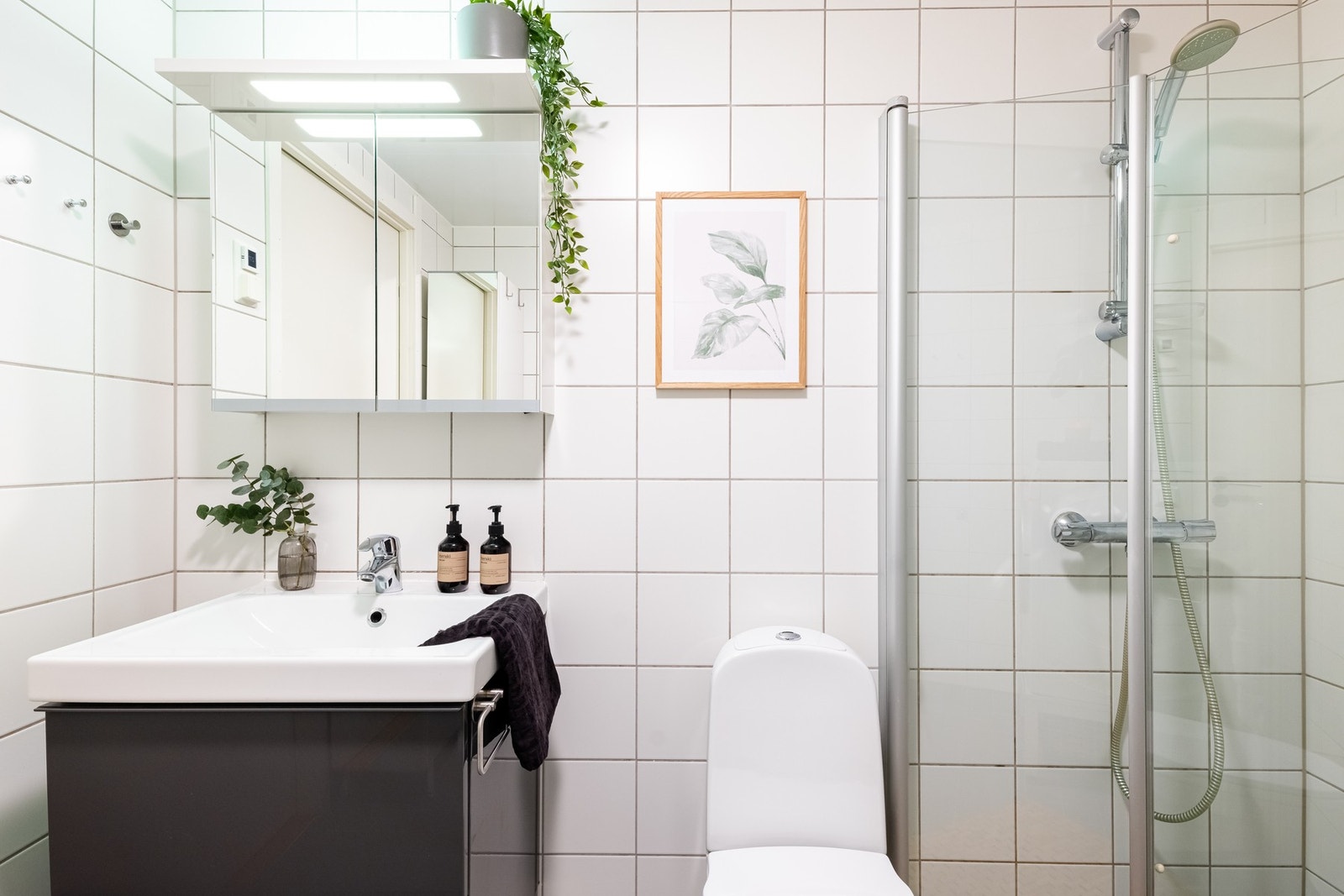 Baderomsinnredningen består av benkeskap med glatte fronter og servant, samt veggskap med speilfronter og belysning over servanten. Galleribilde