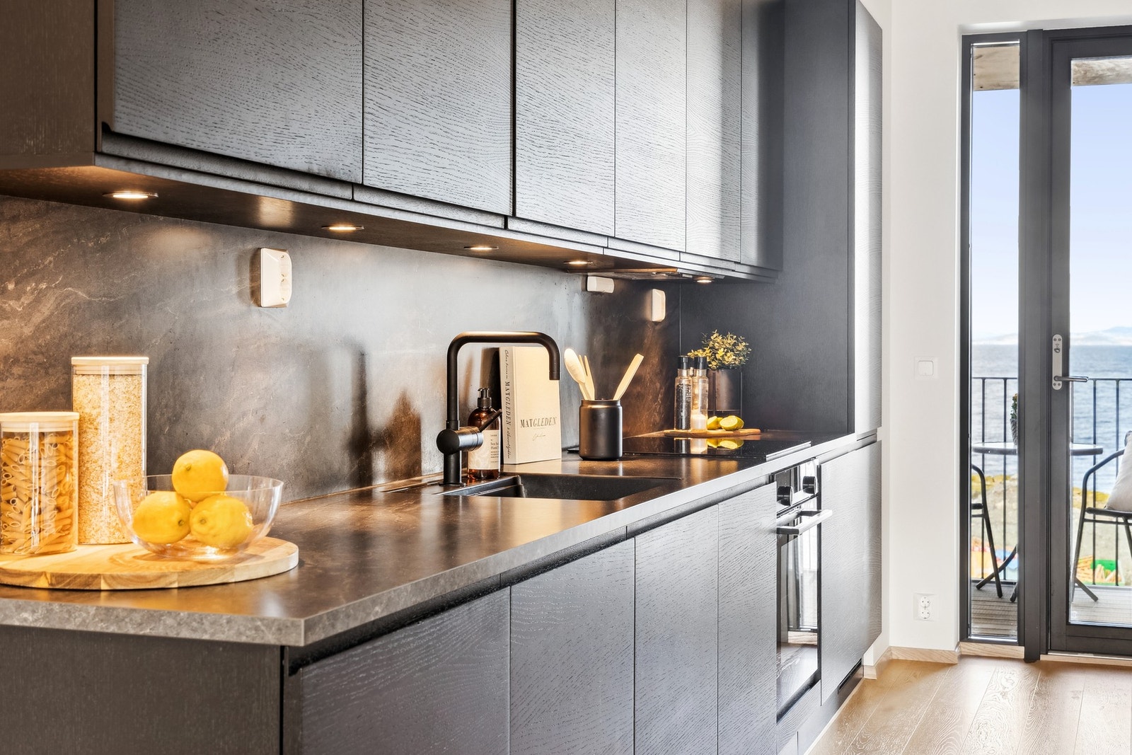 Kjøkkenet har glatte fronter og en slitesterk benkeplate i laminat med nedfelt oppvaskkum og ett-greps armatur. Galleribilde