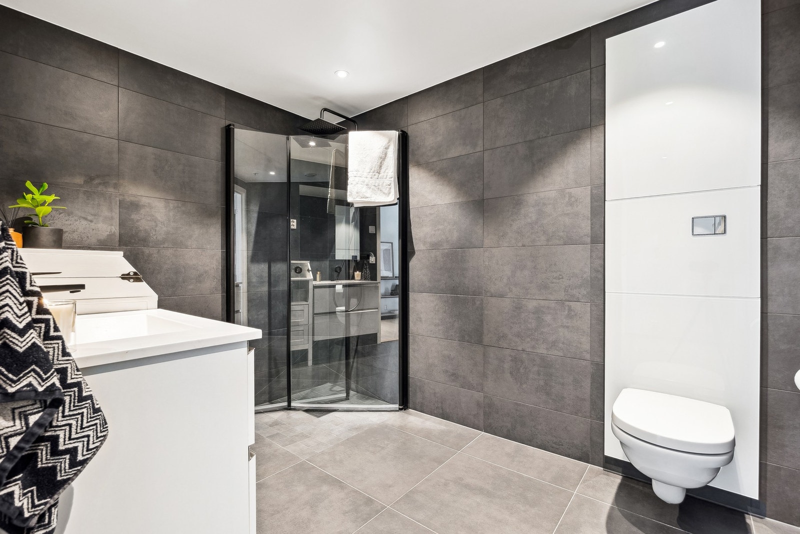 Pent baderom med gjennomgående moderne løsninger. Praktisk dusjhjørne med innfellbare dører. Galleribilde