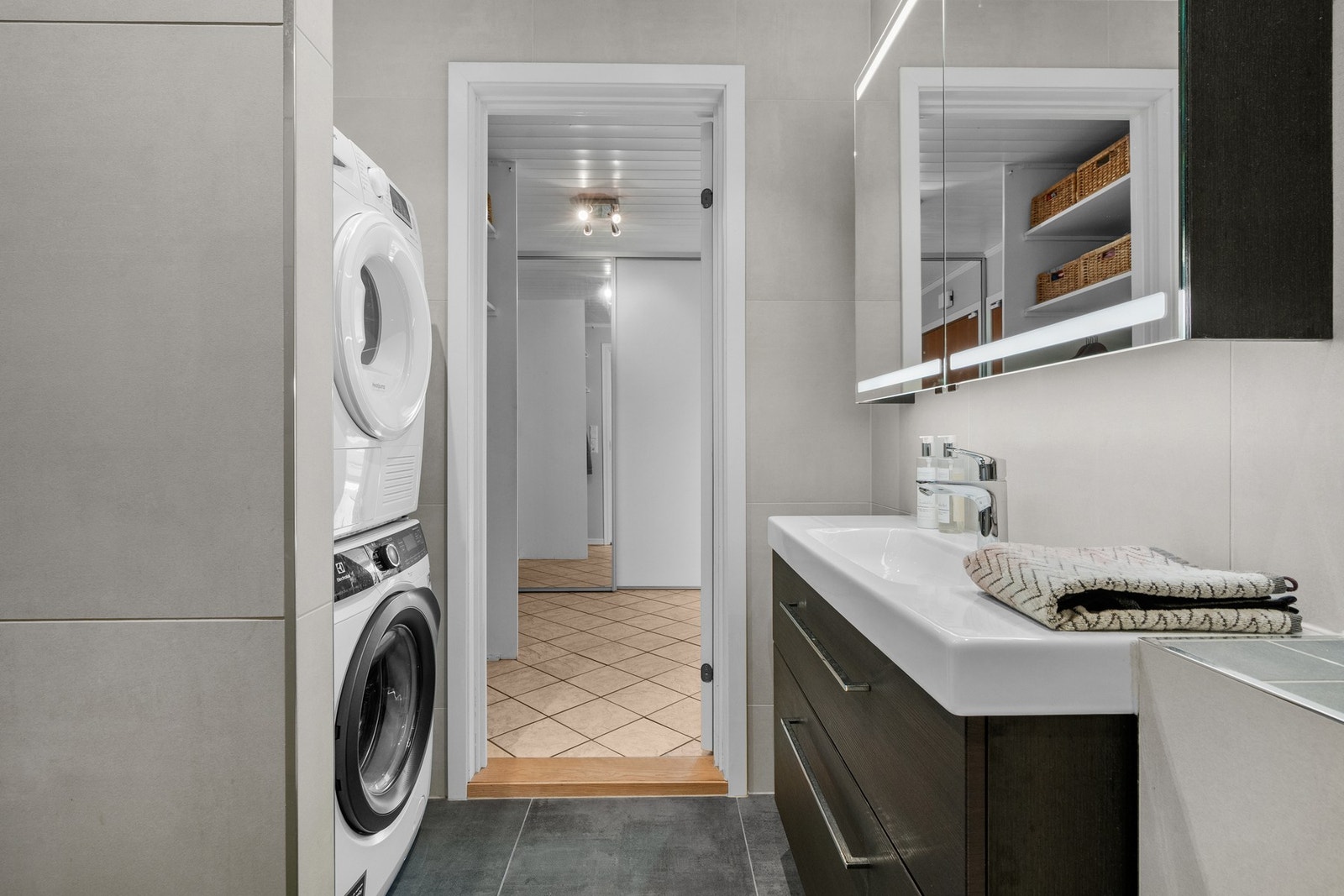 Badet er utstyrt med veggmontert klosett og opplegg for vaskemaskin/vaskesøyle. Galleribilde