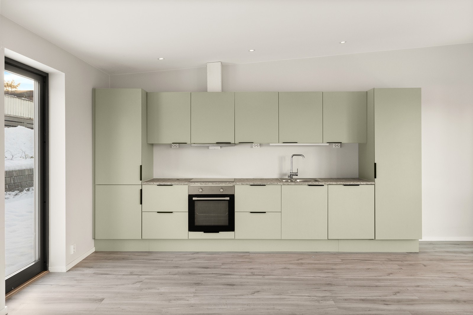 Kjøkkeninnredningen er stilren, og har en dus kontrastfarge på frontene, som mykner opp de lyse overflatene for øvrig. Det er benkeplate av laminat og slette fronter Galleribilde
