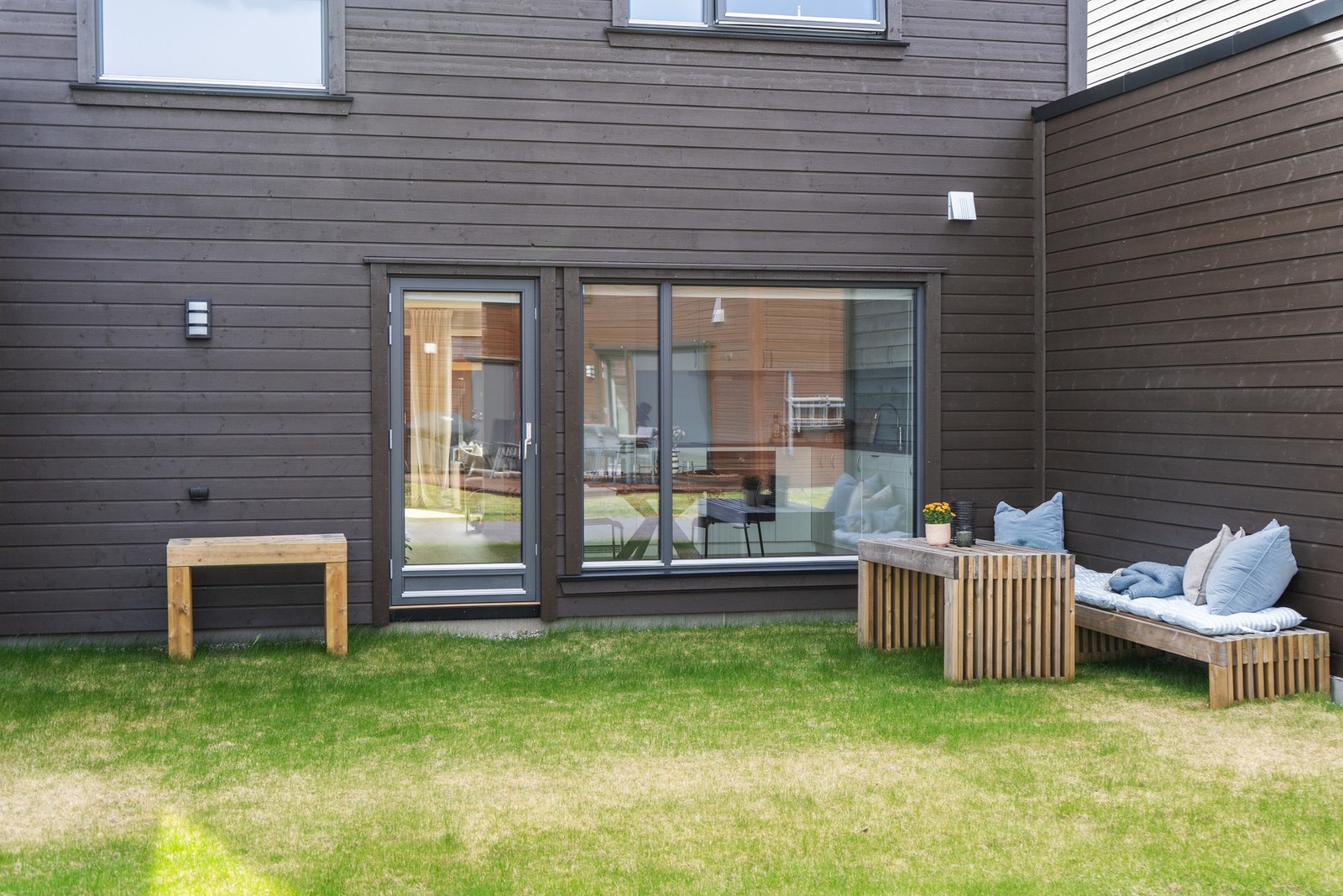 Det er i tillegg til foran - også en hyggelig uteplass på baksiden av boligen. Her kan man fra kjøkkenet følge med på barna som leker på lekeplassen et steinkast unna. Galleribilde