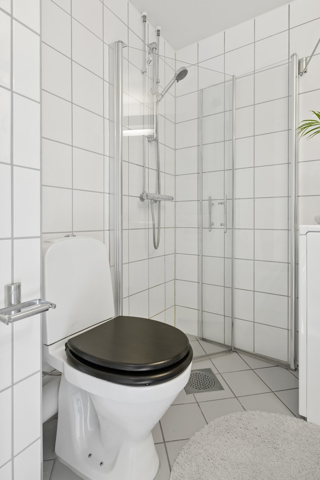 Badet er innredet med dusjhjørne med svingbare glassdører, frittstående toalett, servant med underskap, to overskap og speil med lys. Det er opplegg for vaskemaskin på badet. Galleribilde