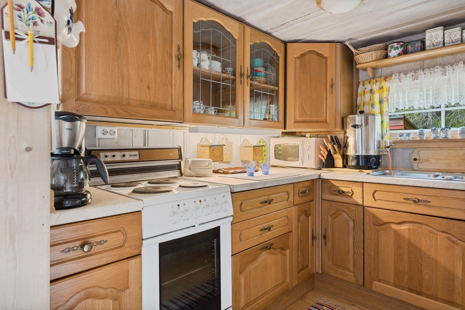 Kjøkkeninnredning med fronter av heltre og benkeplate i laminat. Her er det god benkeplass, og oppbevaringsplass i over- og underskap. Galleribilde