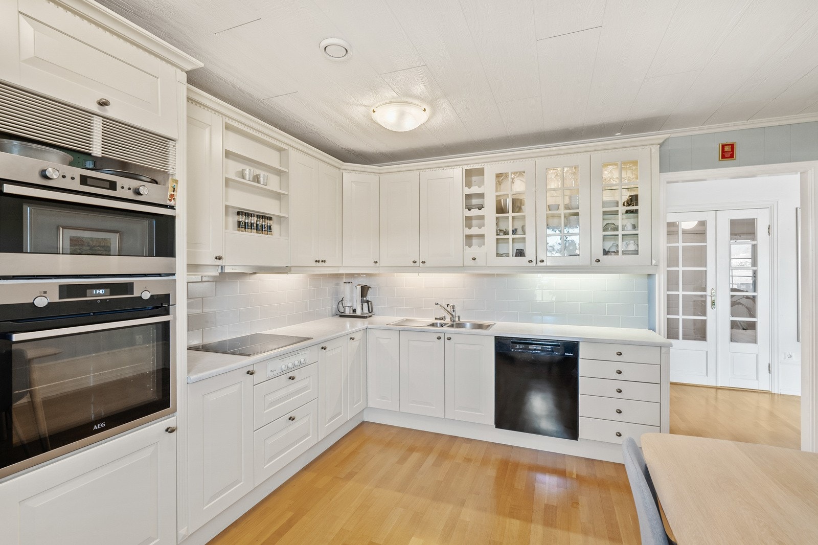 profilerte fronter, og fliser mellom benk og overskap. Integrerte hvitevarer som medfølger. Galleribilde