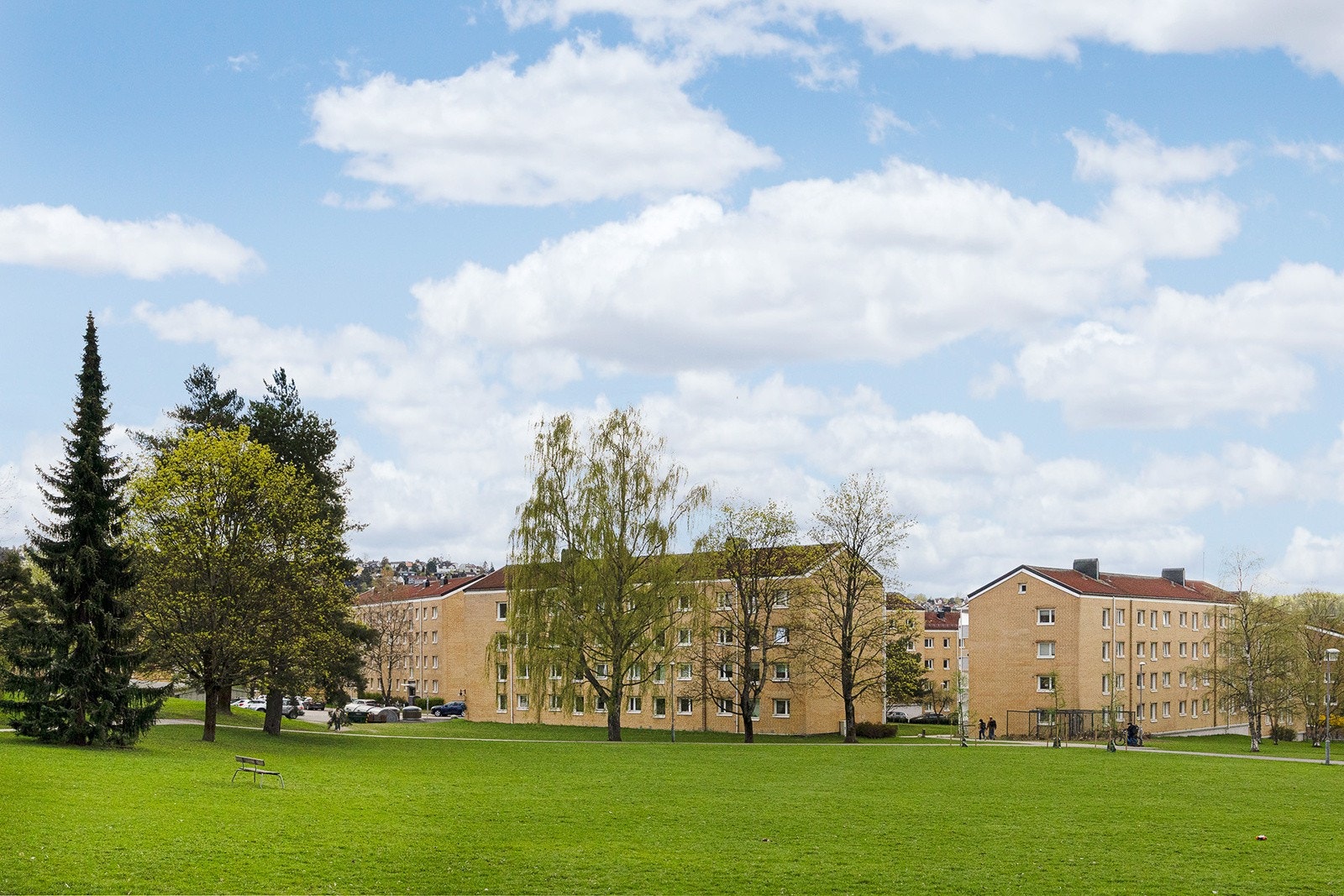 Fasade sett fra kjøkkenside, spisestue og hovedsoverom. Nærområdet er preget av store grønne fellesarealer. Galleribilde