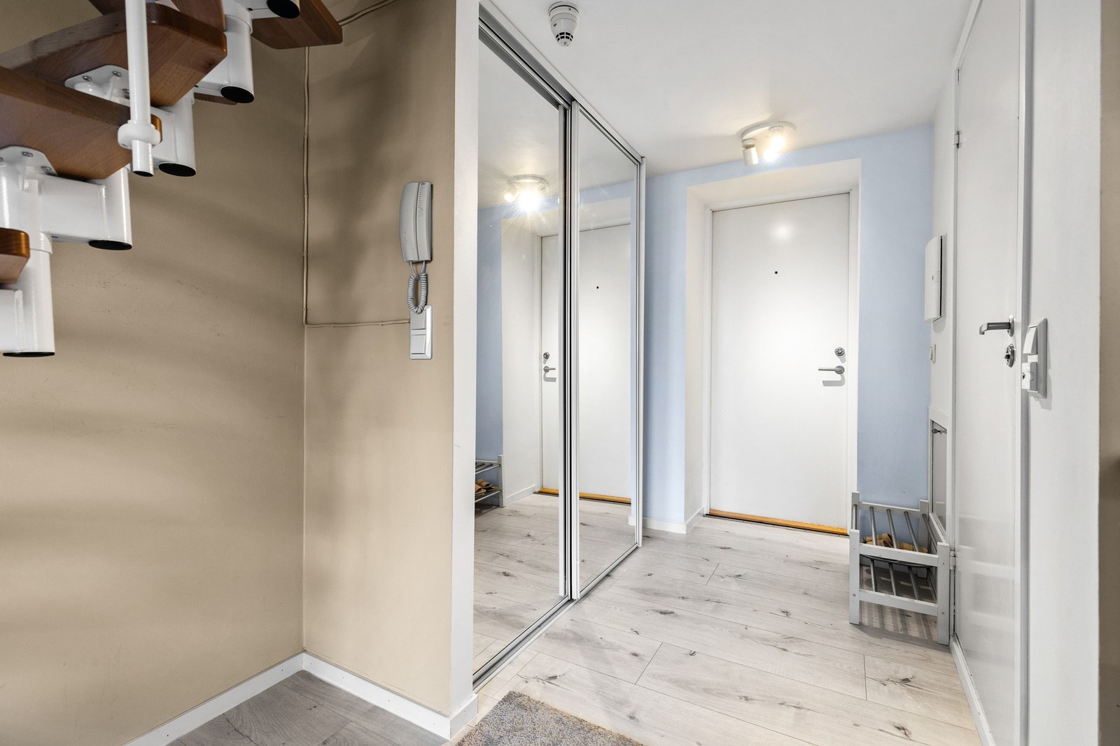 Romslig entré/gang med skyvedørsgarderobe med speilfronter for oppbevaring av yttertøy og sko Galleribilde