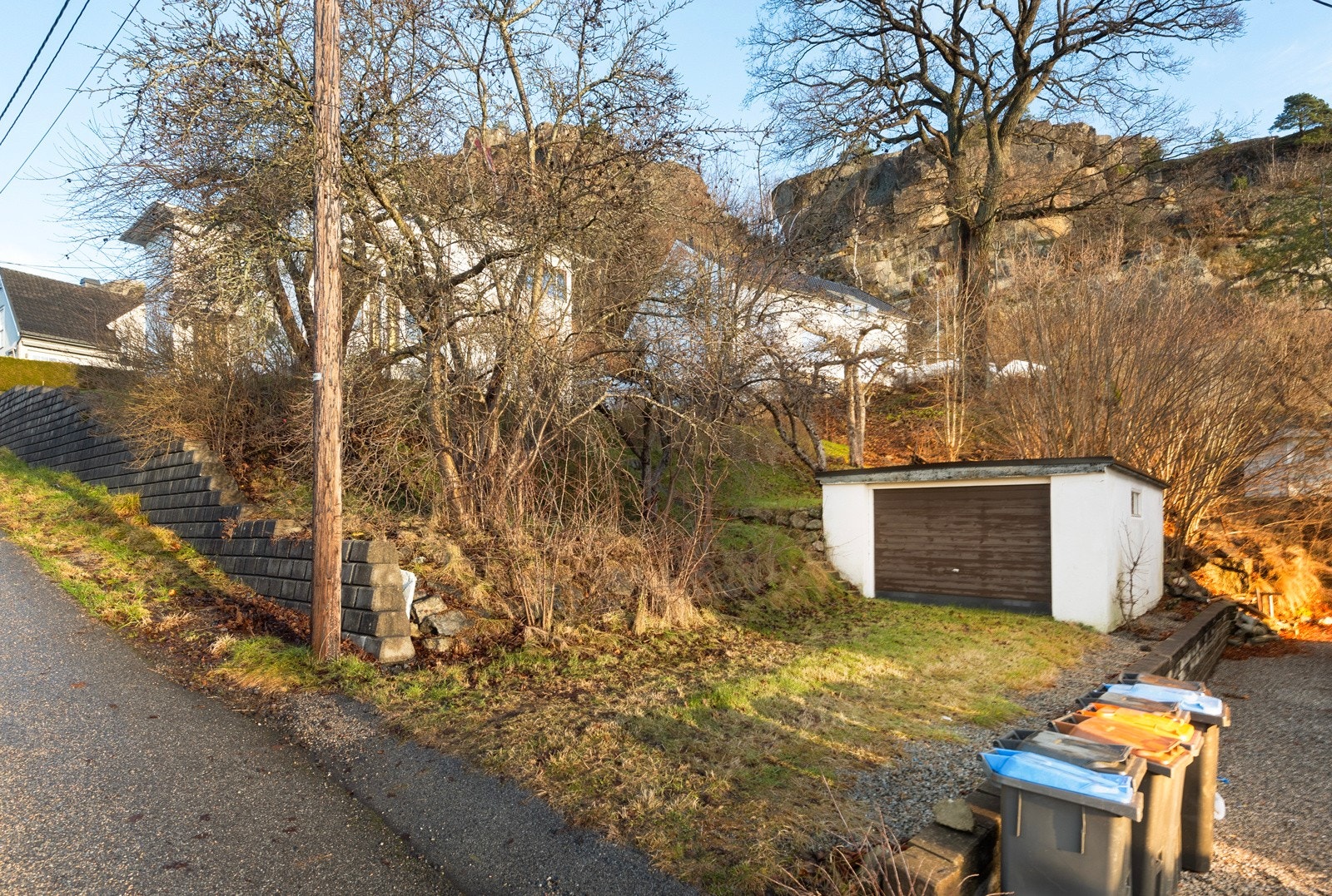På nedsiden av huset har du ekstra mulighet for parkering i garasje i mur med papptekking på tak. Galleribilde