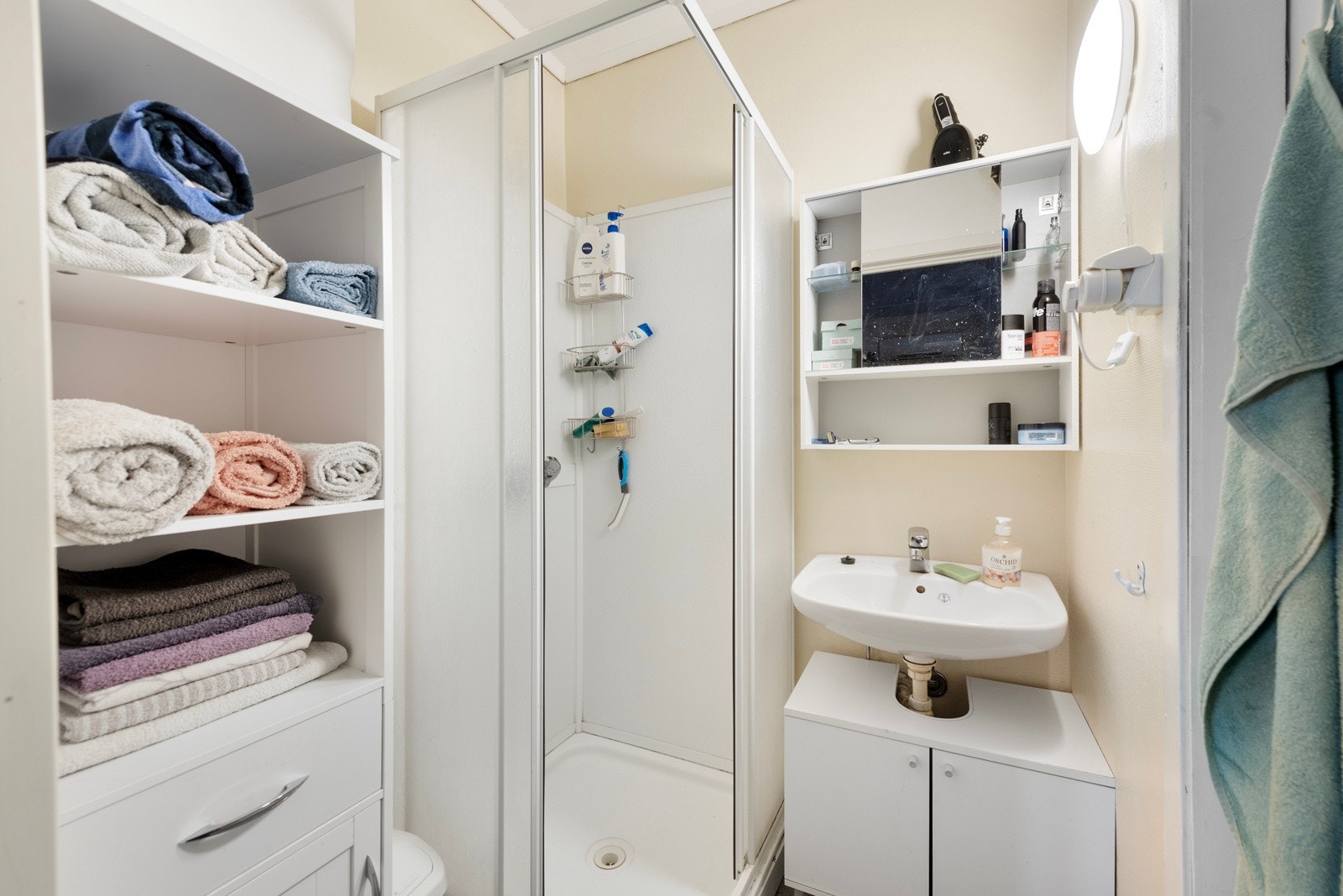 På badet finner du et dusjkabinett og en servant med skapinnredning under Galleribilde