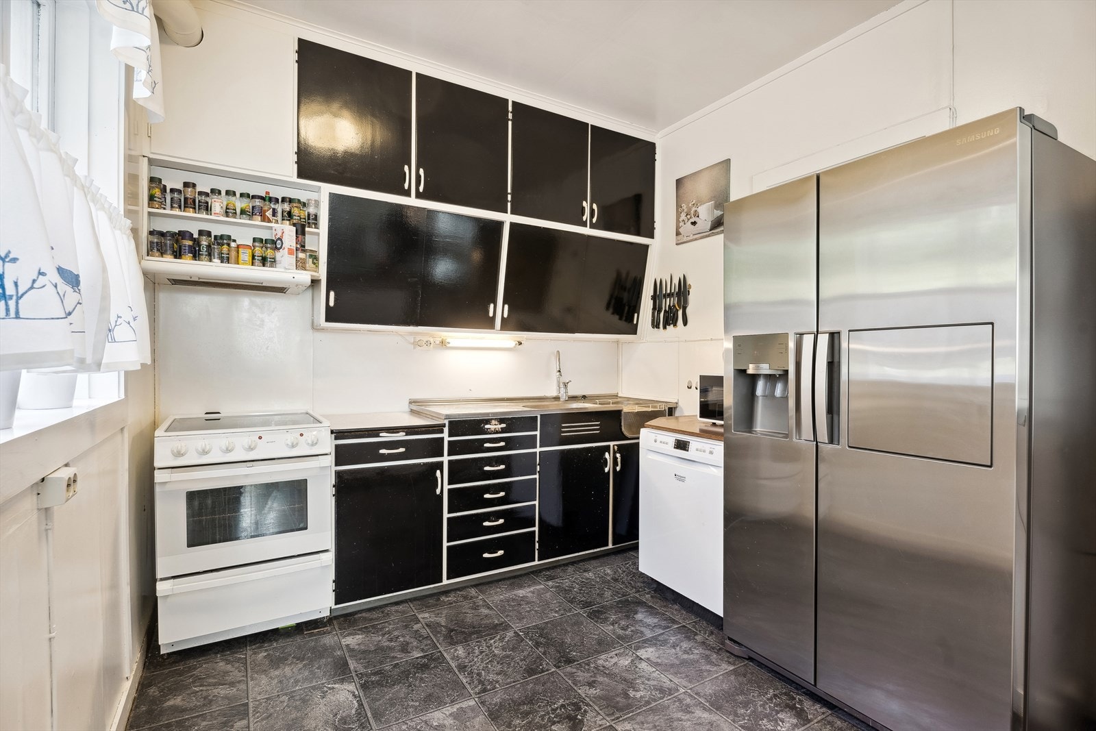 Kjøkken med dels retro innreiing og halvøy for meir benkeplass Galleribilde