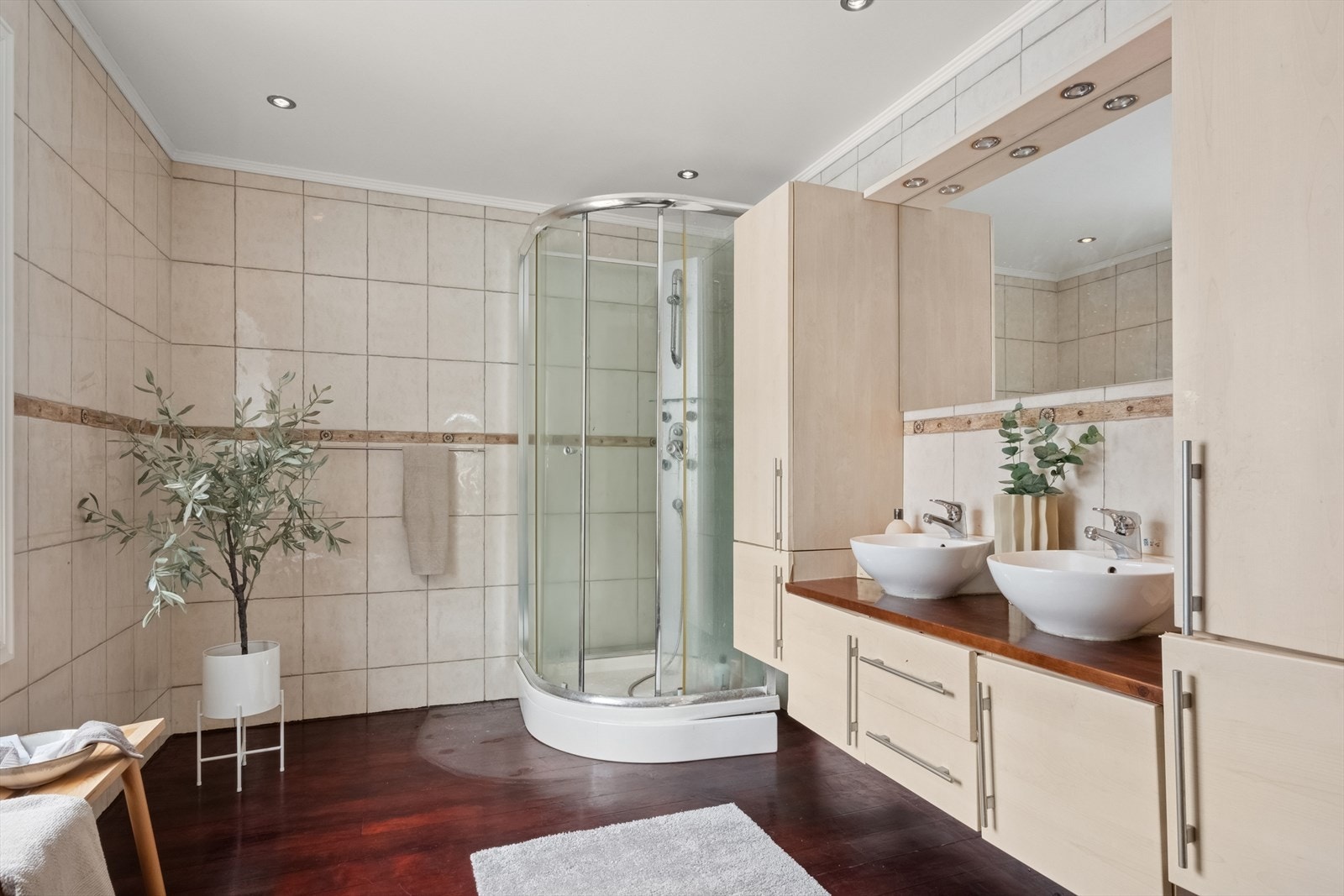 Baderommet som er beliggende i første etasje, er beliggende praktisk til ved soverommene. Videre er rommet utstyrt med baderomsinnredning med to stk. toppmonterte servanter, underskap med skuffer og dører, veggmontert toalett, bidè og dusjkabinett. Galleribilde