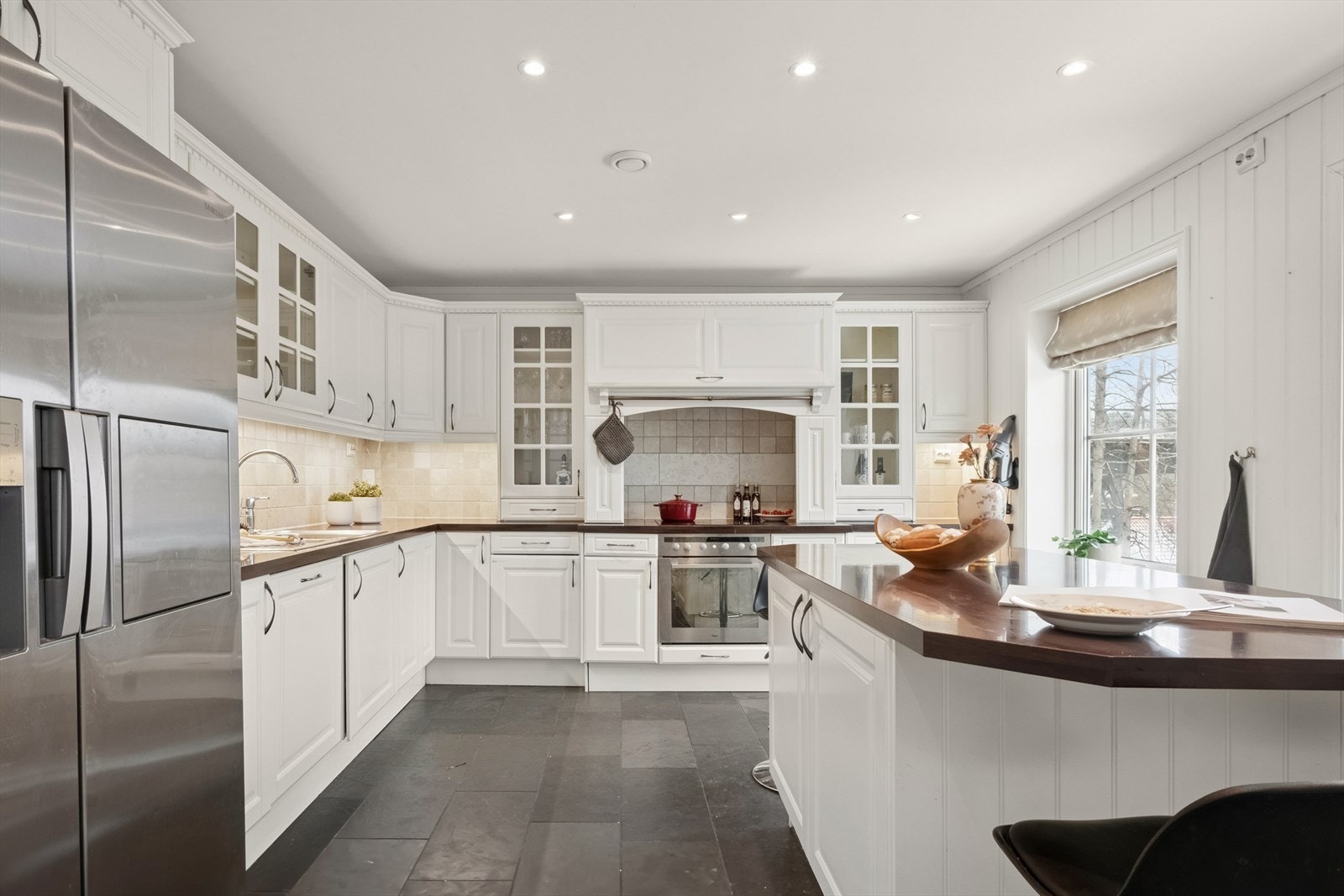 Kjøkkenet er innredet i en praktisk form med godt med skap- og oppbevaringsplass.
Innredningen er med profilerte fronter og benkeplate i laminat. Kjøkkeninnredningen er fra byggeår og er av merket Drømmekjøkken. Galleribilde