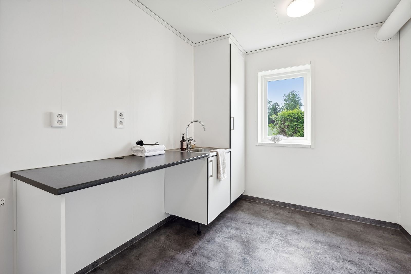 Romslig vaskerom (teknisk rom) med egen utgang til siden av boligen. Galleribilde