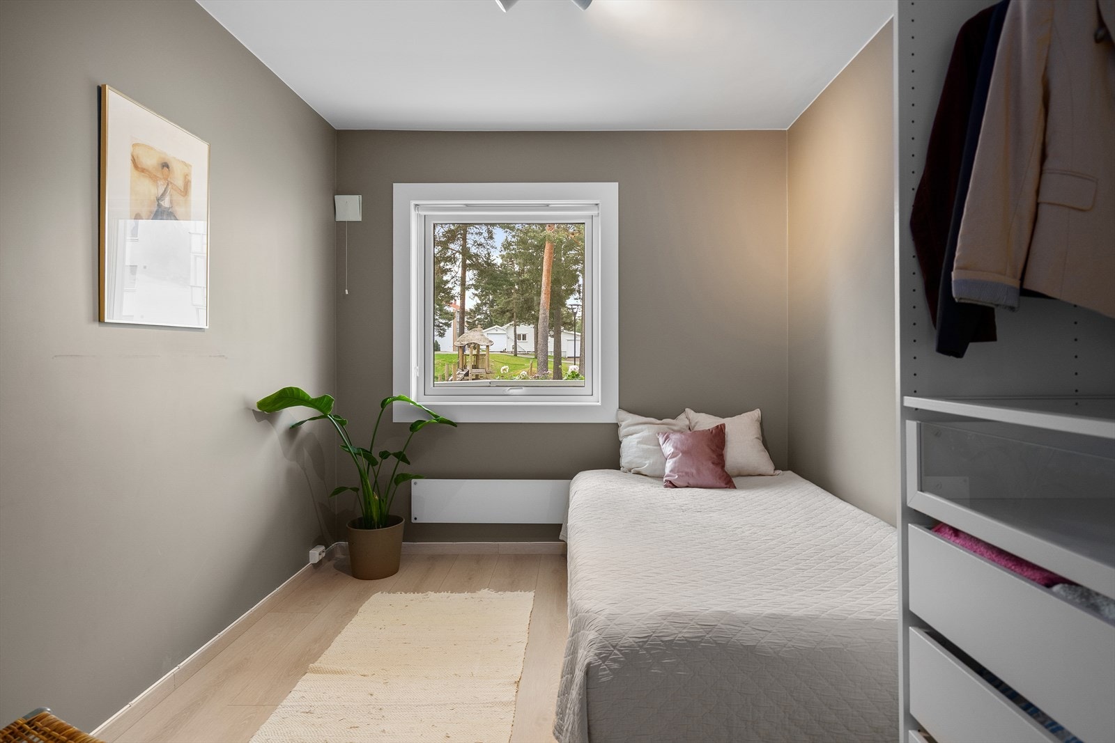 Soverom 2 har også god størrelse og er som resten av boligen, malt med lune farger på veggene. Gulvet har en tilsvarende overflate som bidrar til et sammenhengende uttrykk i hele boligen. Galleribilde