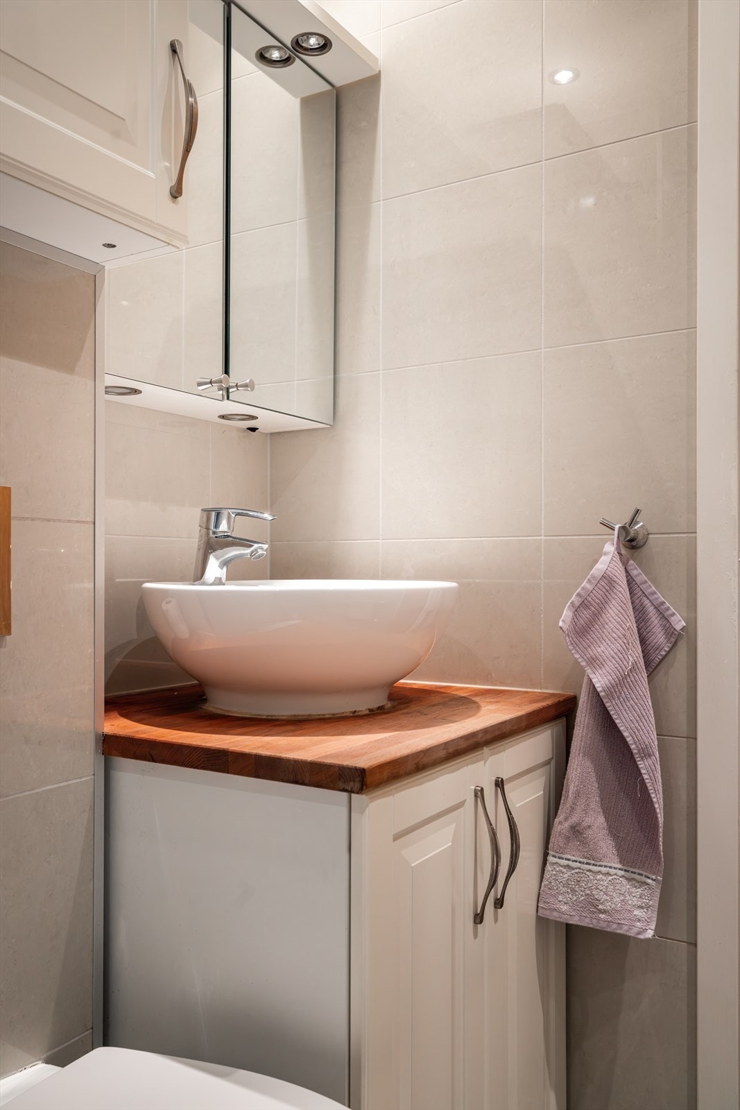 Badet er utstyrt med vegghengt toalett med innebygd sisterne, servant i helstøpt plate, dusjhjørne med dører i herdet glass, og opplegg for vaskemaskin. Galleribilde