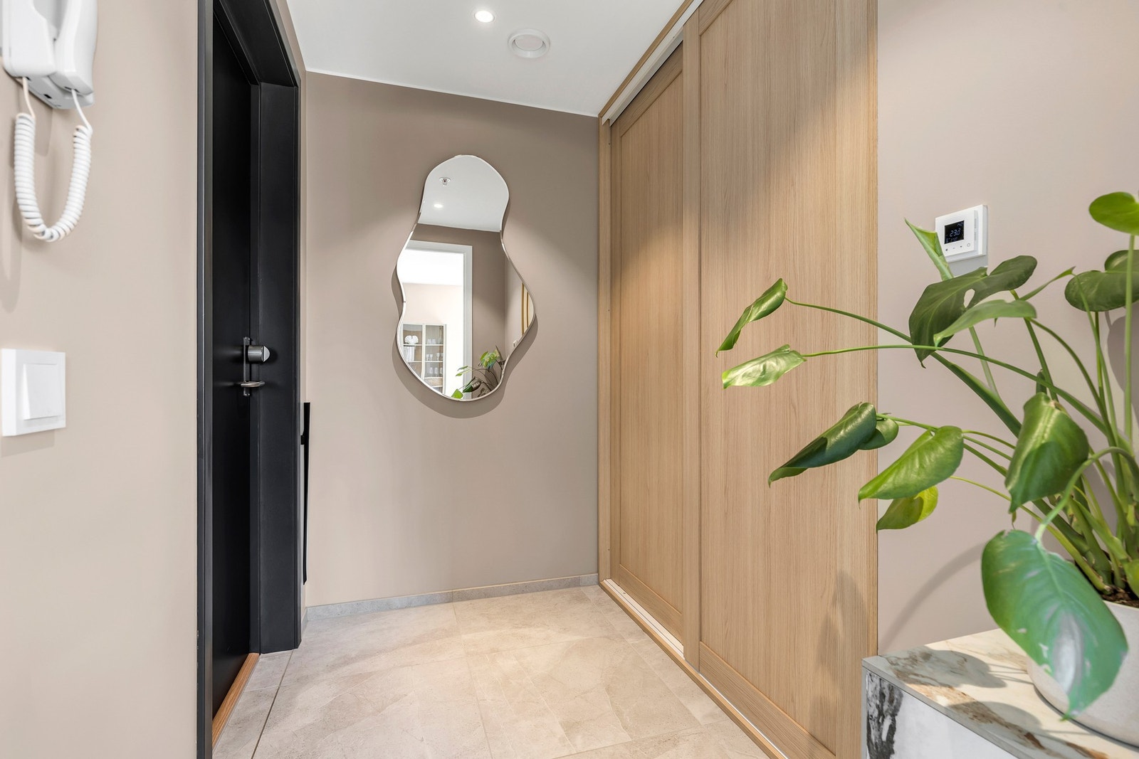 Entréen er oppgradert med 60x60-fliser og skyvedørsgarderobe fra Drømmekjøkkenet. Det er montert DanaLock på døren som gjør at man kan åpne og lukke med telefon, kode eller nøkkel. Galleribilde