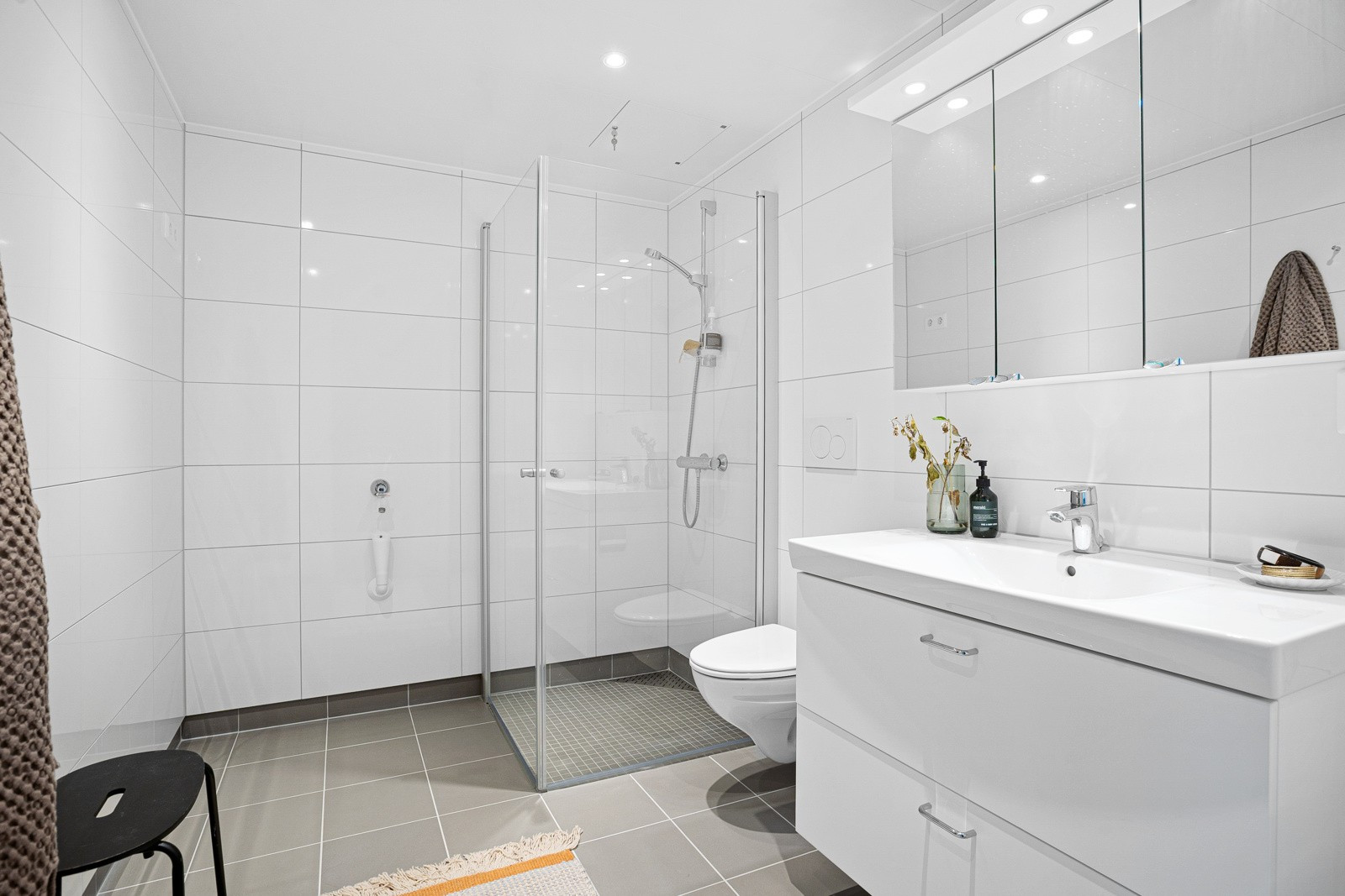 Flislagt bad med stort dusjhjørne, vegghengt wc, varme i gulv og downlights i himling. (Bildet er hentet fra en tilsvarende leilighet i etasjen under)
