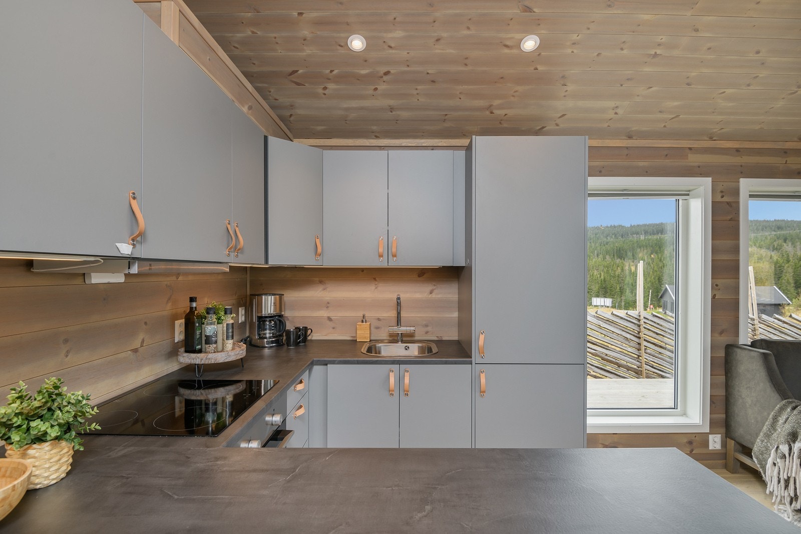 Benkeplaten er laminert og utstyrt med kjøkkenkum og kran. Galleribilde