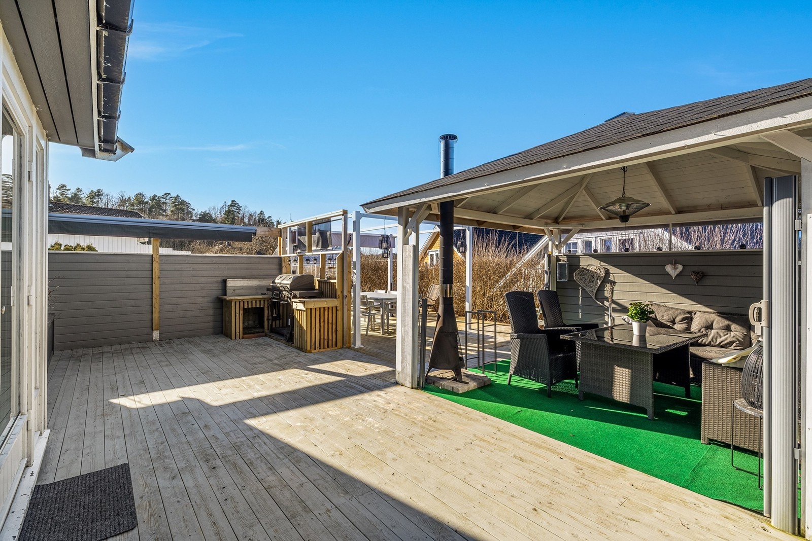 Utekjøkkenet med plass til grill er i flittig bruk gjennom hele sommeren. Flere sittegrupper gir valgmuligheter i en usjenert og solrik hage. Galleribilde