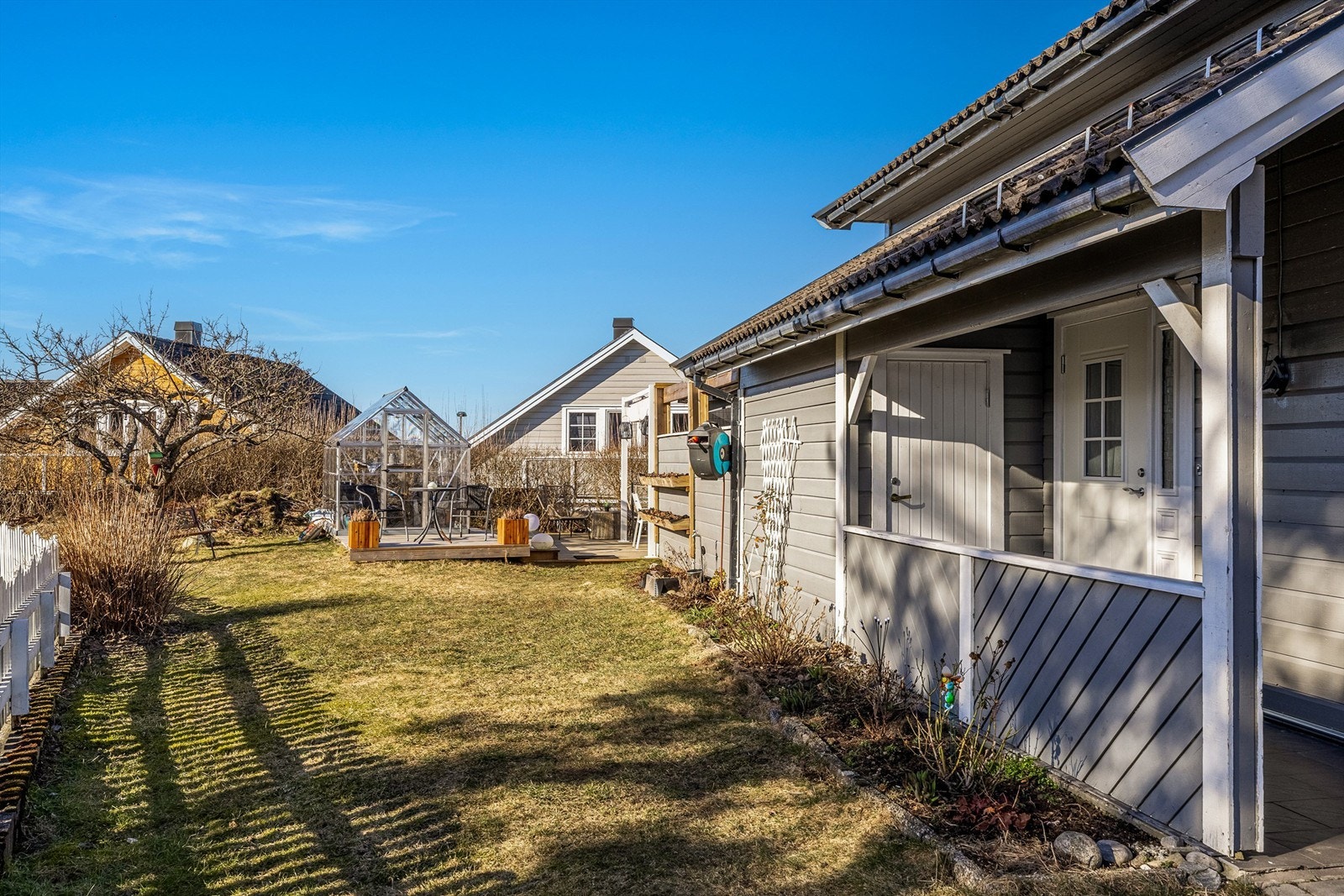 Oversiktlig hage med plen, prydbusker og bed. Galleribilde