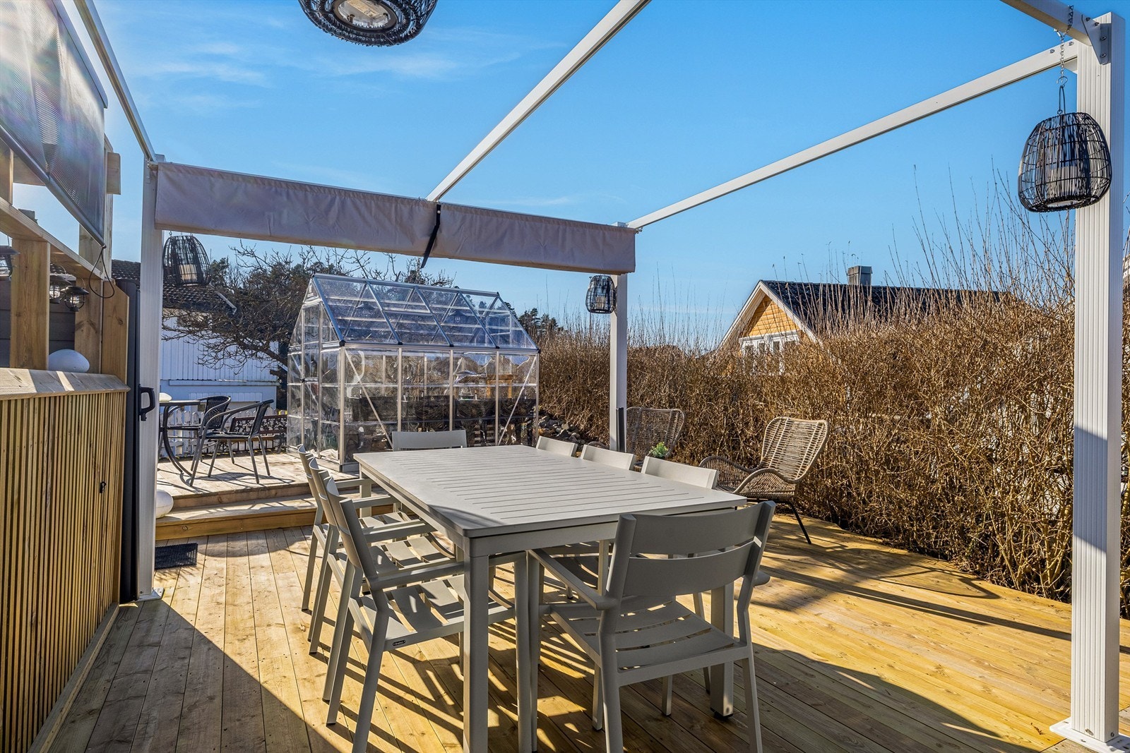 Spiseplassen ligger vegg i vegg med utekjøkkenet og har en enkel pergola løsning som gir skygge ved behov. Galleribilde