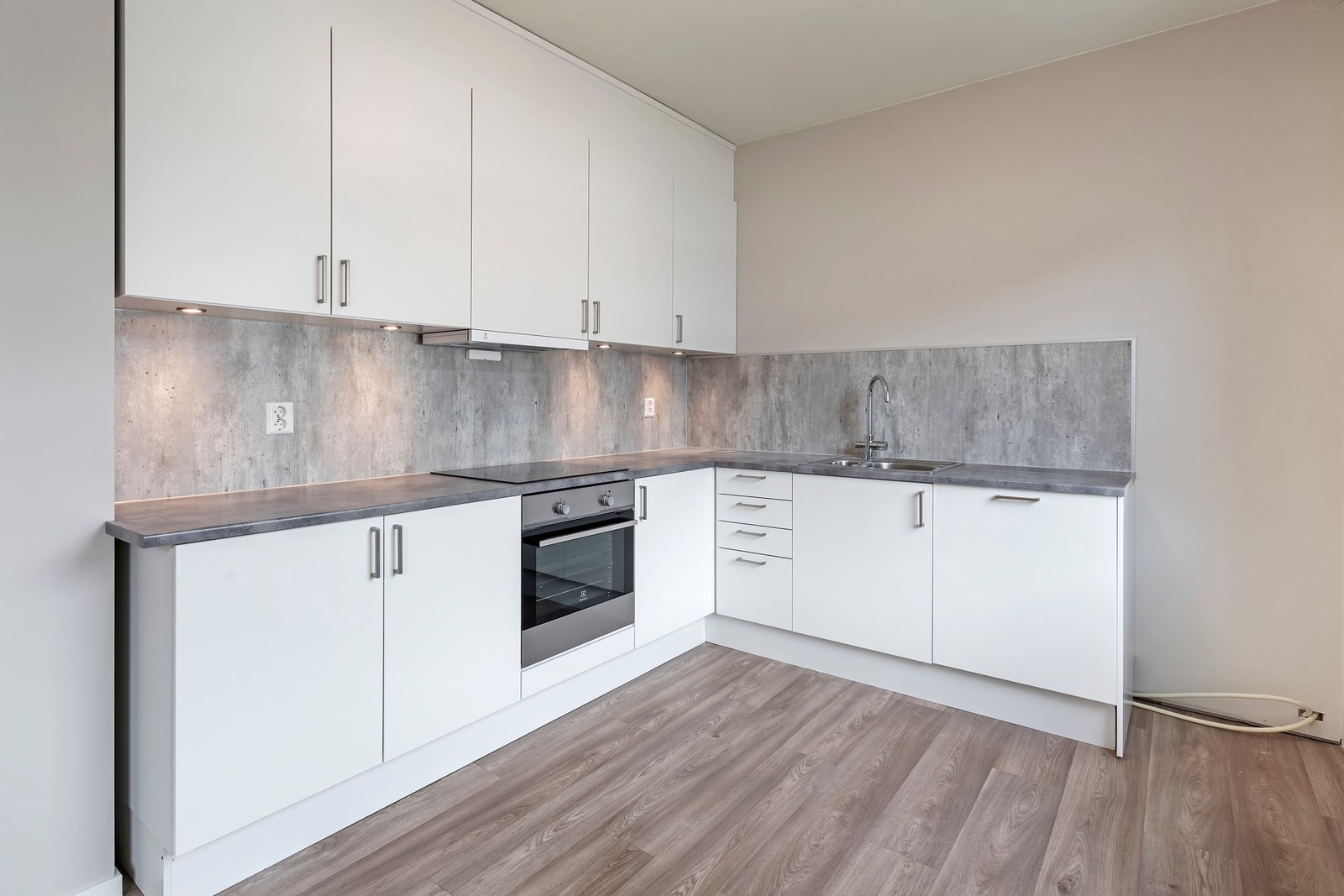 Nyere kjøkkeninnredning med takhøye overskap og spotter montert Galleribilde