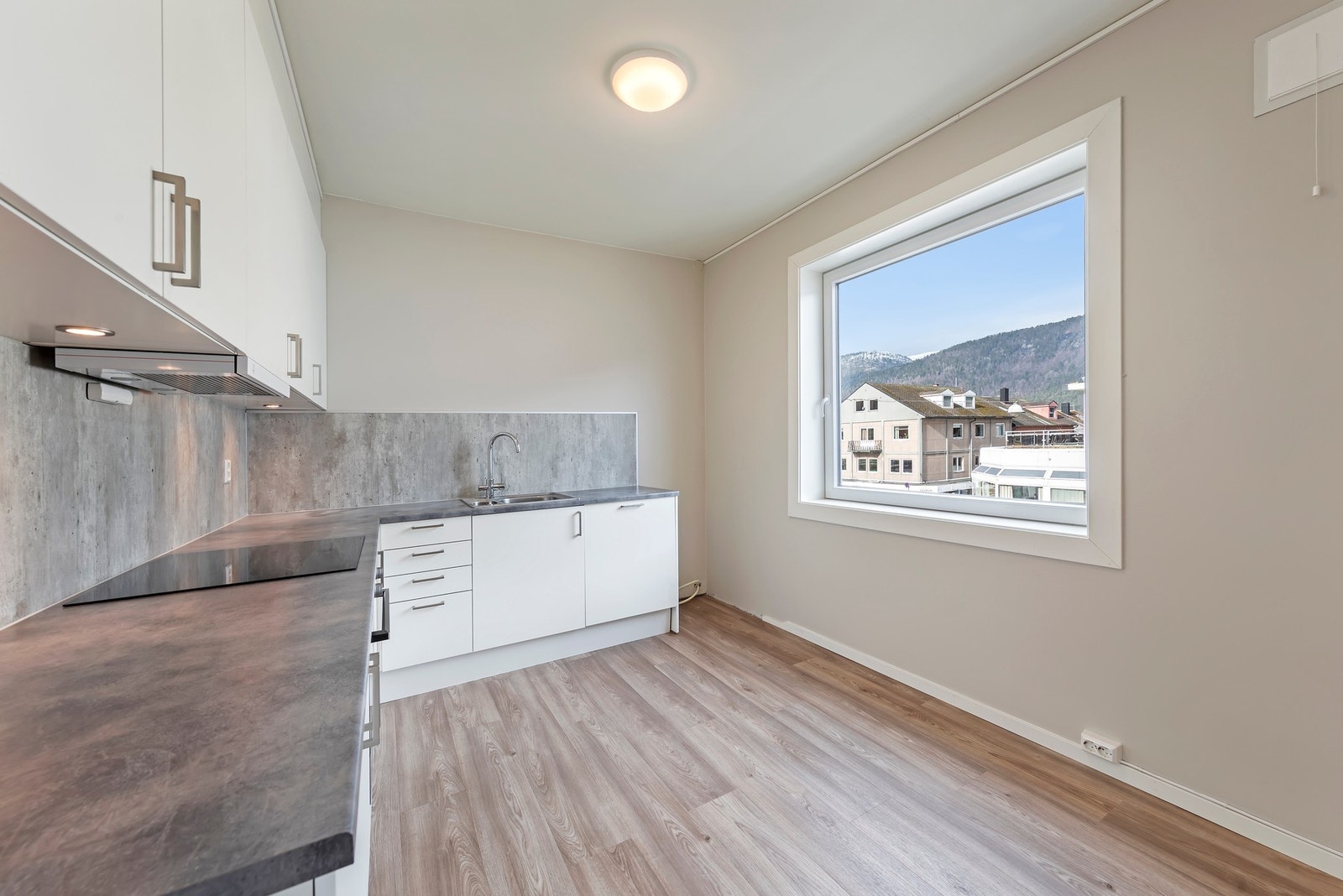 Kjøkkenet har integrerte hvitevarer og plass avsatt til kjøleskap Galleribilde