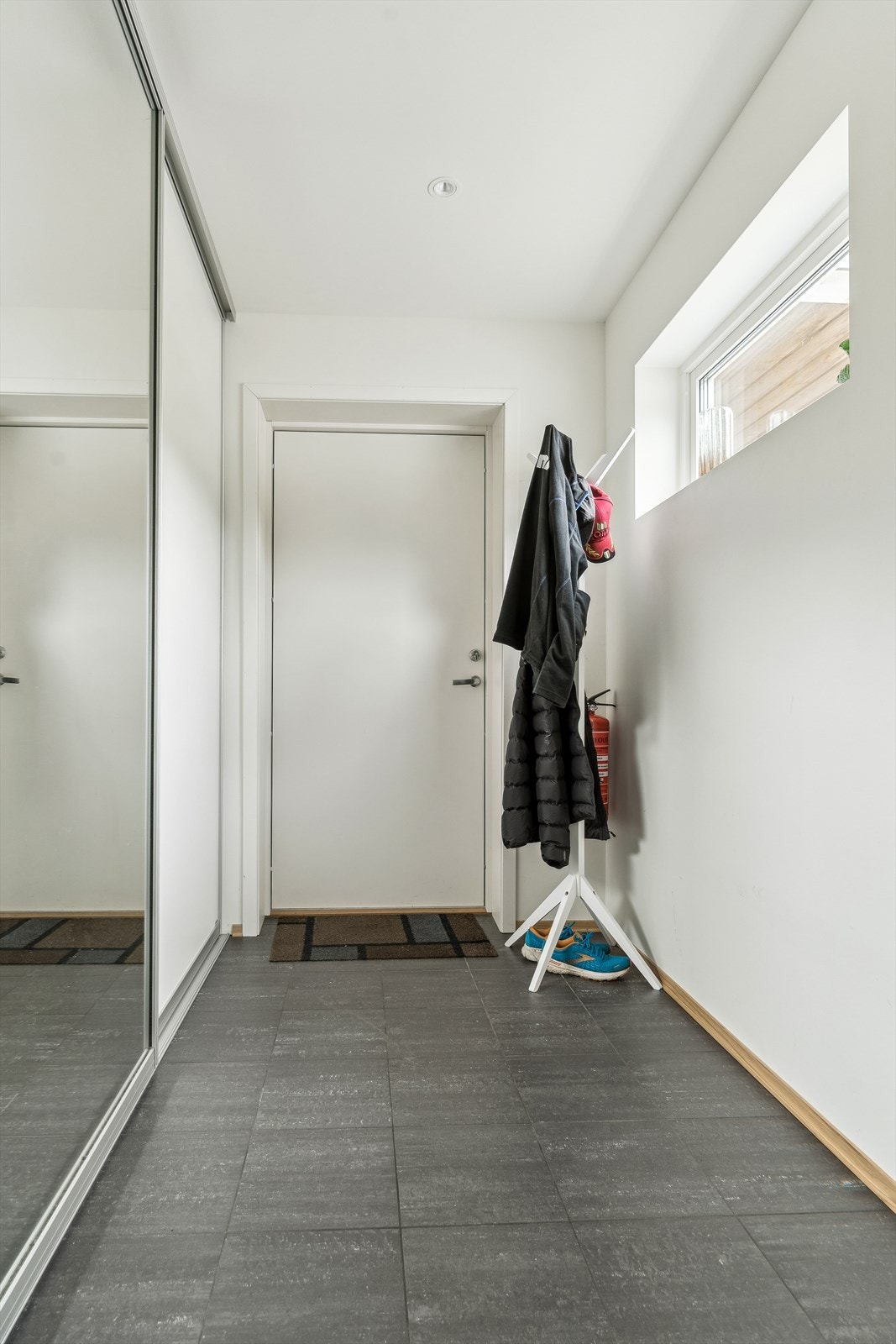 Velkommen inn! Her har du god plass til oppbevaring i skyvedørsgarderobe. Flis på golv og lyse fargar på veggar. Galleribilde