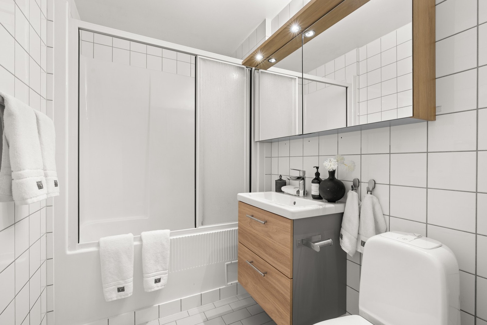 Det er innredet med vegghengt servantskap med glatte fronter og speilskap fra 2024, heldekkende servant med ett-greps armatur, speilskap med belysning og stikkontakter, innebygget badekar/dusjkabin med ovenpåliggende skyvbare glassfelt, samt toalett. Galleribilde