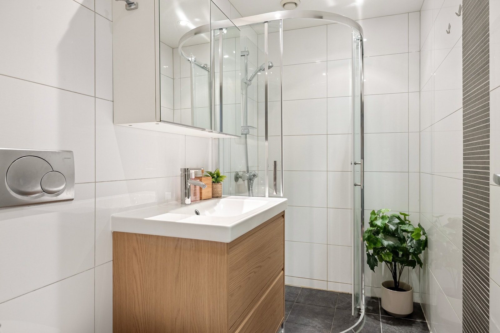 Det helflisede badet fremstår moderne og er innredet med dushjørne, vegghengt toalett og baderomsinnredning. Galleribilde