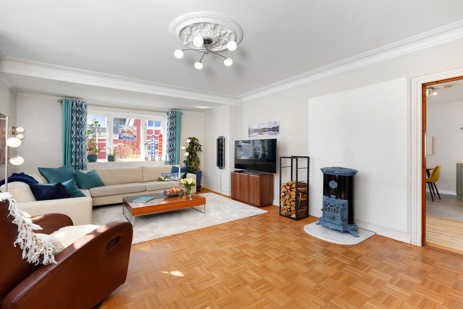 Pen parkett i rutemønster, og en lekker, eldre vedovn. Galleribilde