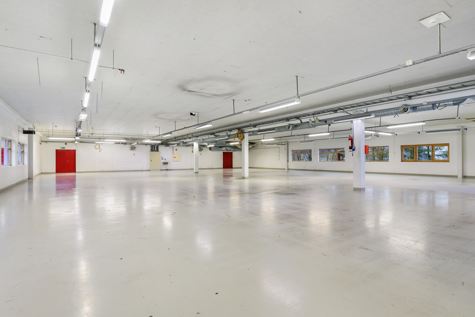 De ledige lokalene i u. etg. Innvendige mål er 22 meter bredde og 28,8 meter. Takhøyde ca. 3,3 meter. Egen rulleport på 4 x 3 meter.
