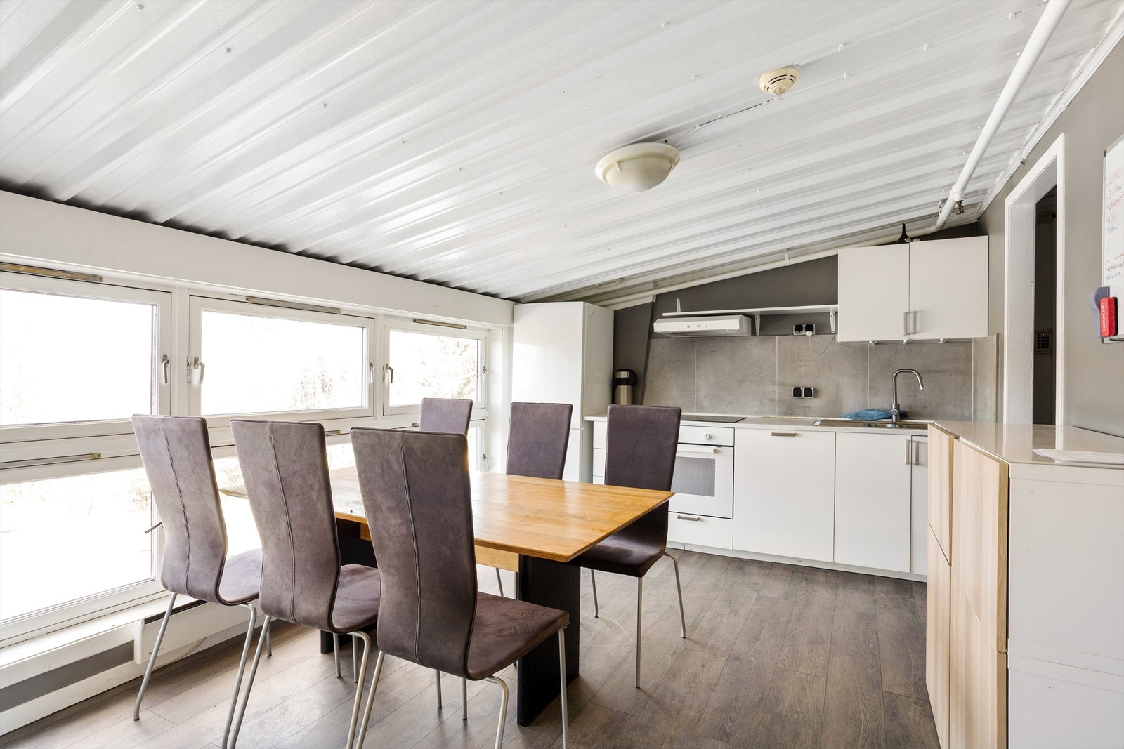 Fullt innredet kjøkken med spiseplass på mesanin. Galleribilde