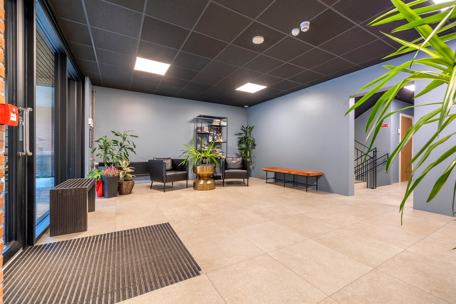 Bygget har heis til alle etasjene og innbydende oppganger med flislagt gulv. Leilighetens ytterdør er utstyrt med smart kodelås og entreen er pent utført med lyse fliser på gulvet, glatte, gråmalte veggflater og listefri himling med downlights. Galleribilde