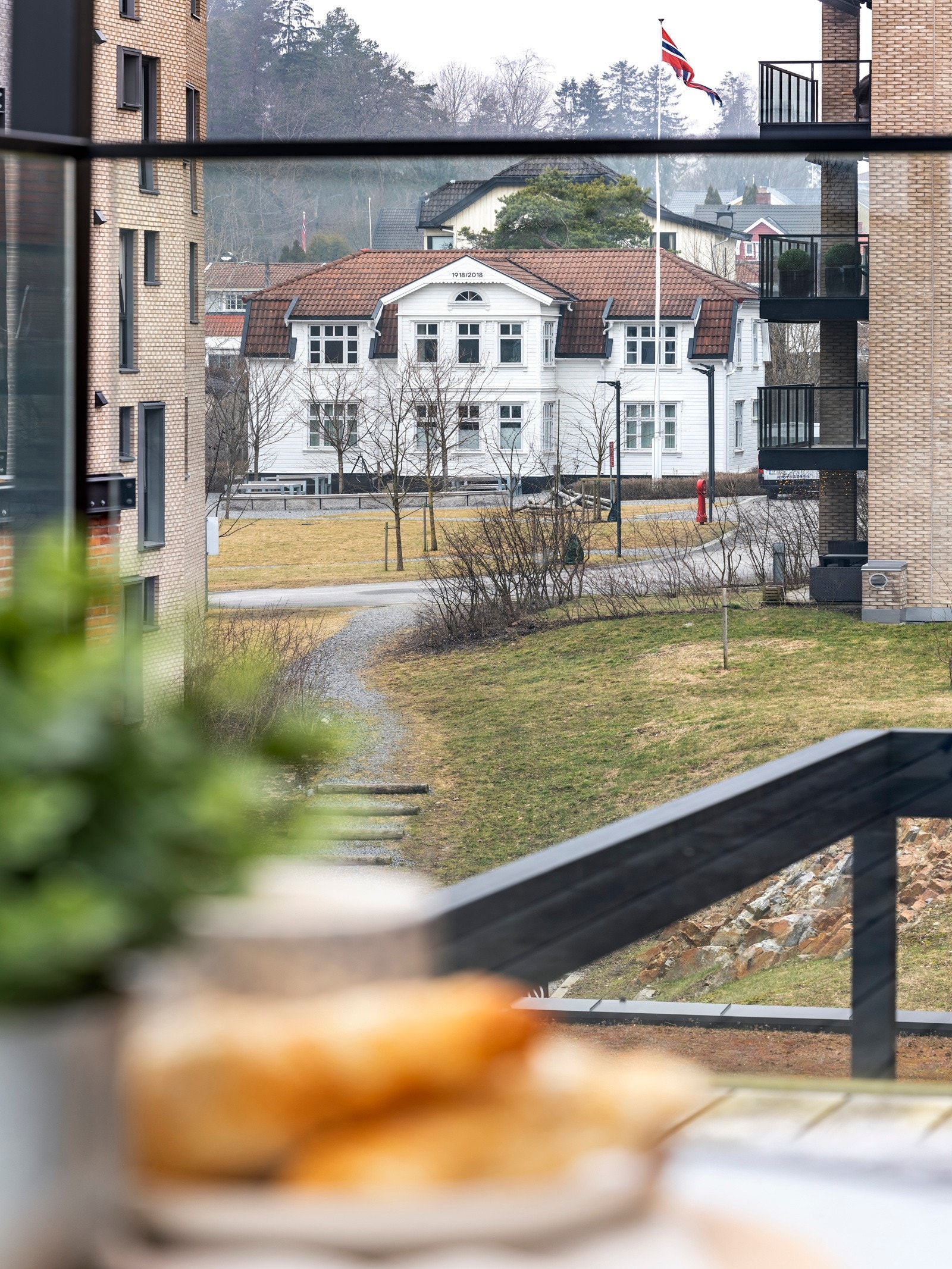 Leiligheten har flott utsikt sydover mot bebyggelsen og grønne åser i horisonten. I motsatt retning strekker utsynet seg mot Villa Breskeskjær fra 1918, som ble flyttet til tomten i 2018. Galleribilde
