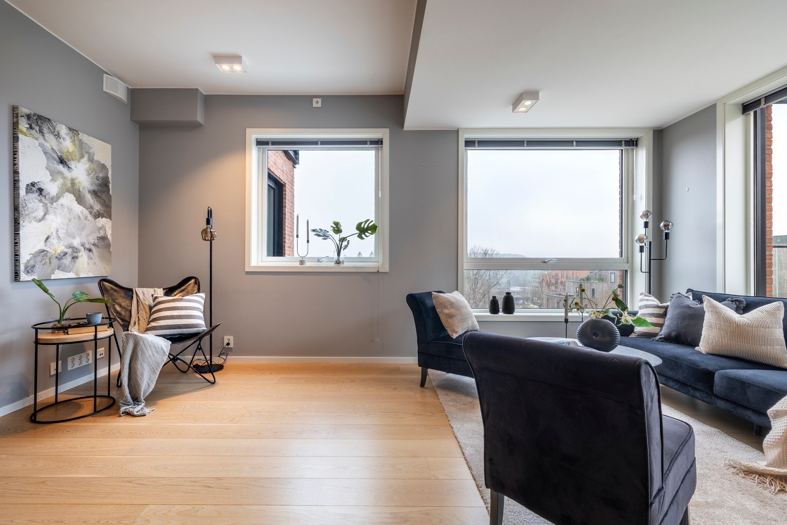 Sonene markeres av nedsenket himling i stuen og noe høyere himling over kjøkkensonen. Det hele rammes inn av pene overflater med enstavs parkettgulv, glatte, gråmalte vegger, nedfelte downlights og vannbåren gulvvarme. Galleribilde