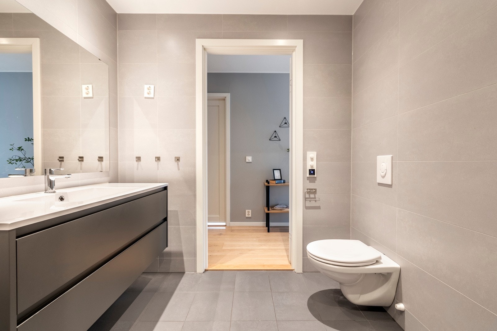 Leiligheten har to pene bad med moderne standard. Det ene ligger i suite med hovedsoverommet, mens det andre har adkomst fra gangen og er kombinert vaskerom. Sistnevnte har nisje til vaskemaskin, og eventuelt tørketrommel i søyle, bak en smal skillevegg. Galleribilde