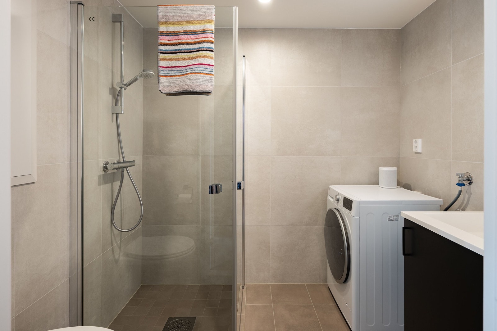 Badet har gulvvarme og opplegg til vaskemaskin Galleribilde