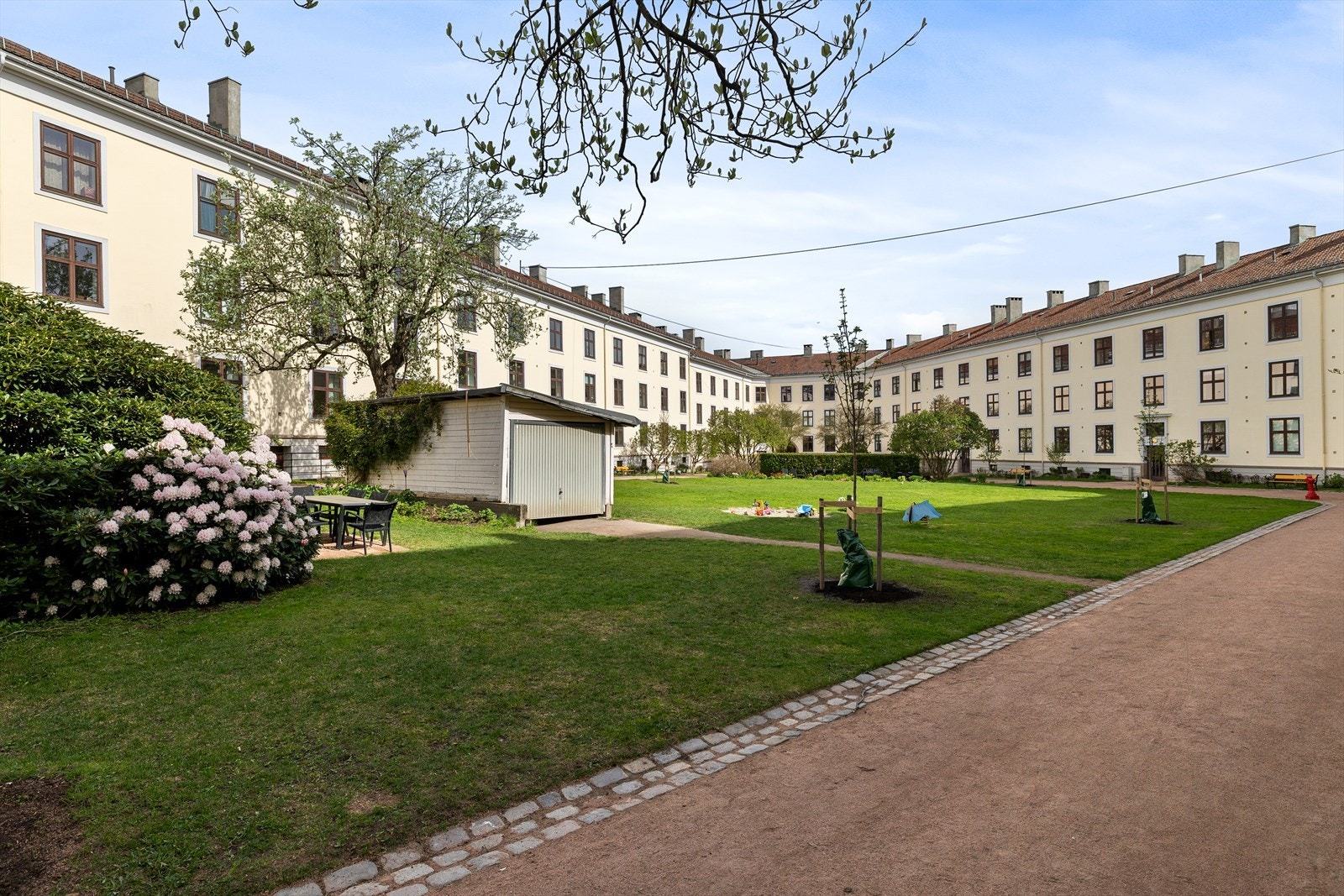 Her får man følelsen av å ha en liten park rett utenfor døren. Svært godt ivaretatt, frodig og fargerik med bl.a. syriner, magnolia, peoner, hortensia, tulipaner og roser Galleribilde