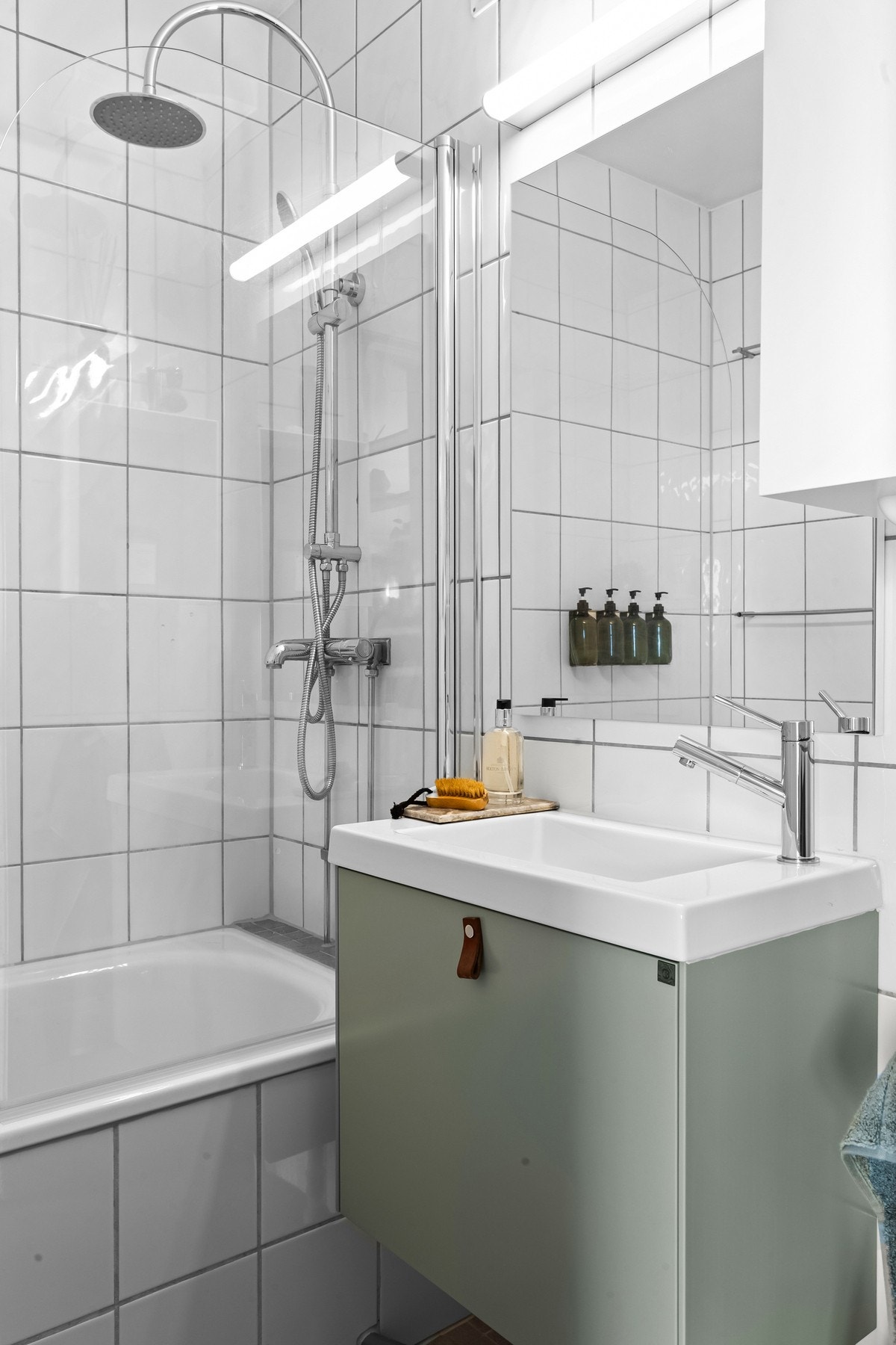 Badet har innebygd badekar og regnfallsdusj. Videre er det servantskap med speil over og vegghengt wc. Galleribilde