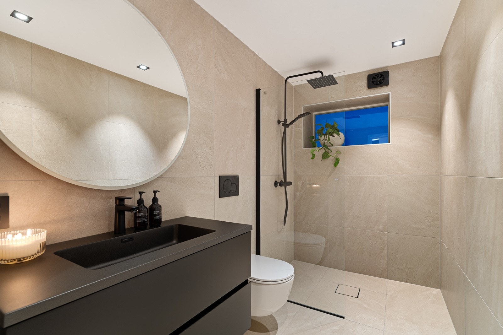 Badet i 1. etasje, moderne baderomsinnredning og tilhørende smekkert speil Galleribilde