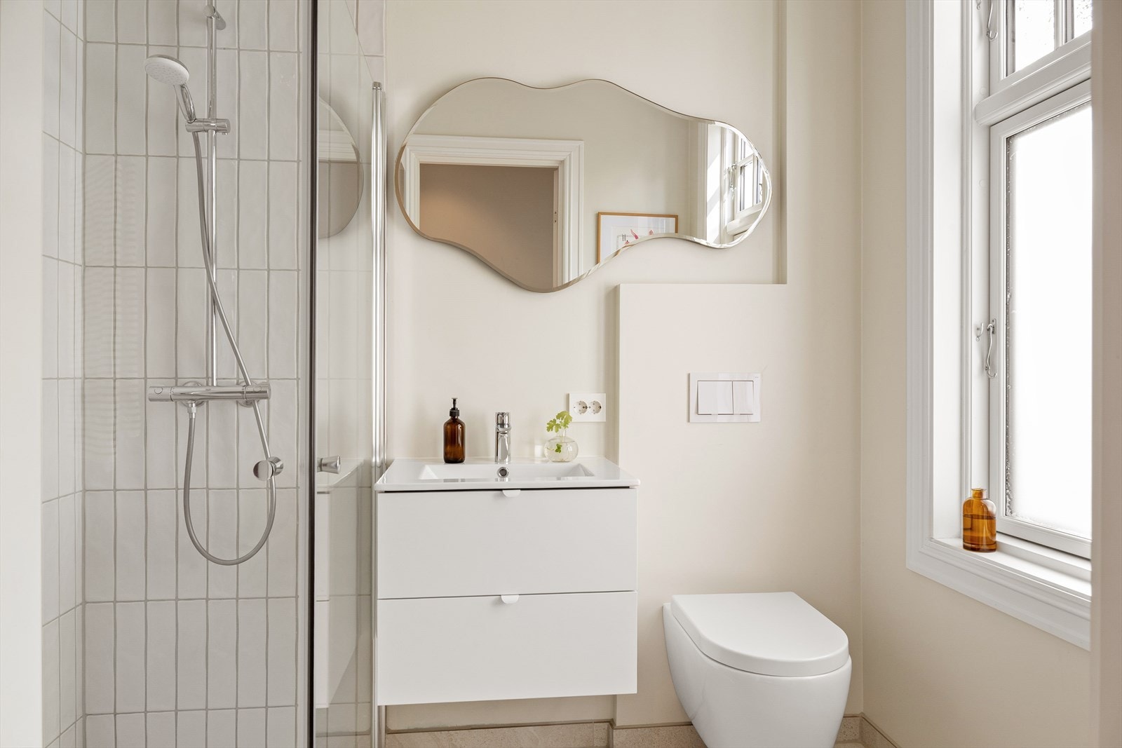 Stilrent bad med fliser og elektriske varmekabler i gulv, samt vegger med fliser og malte plater. Galleribilde