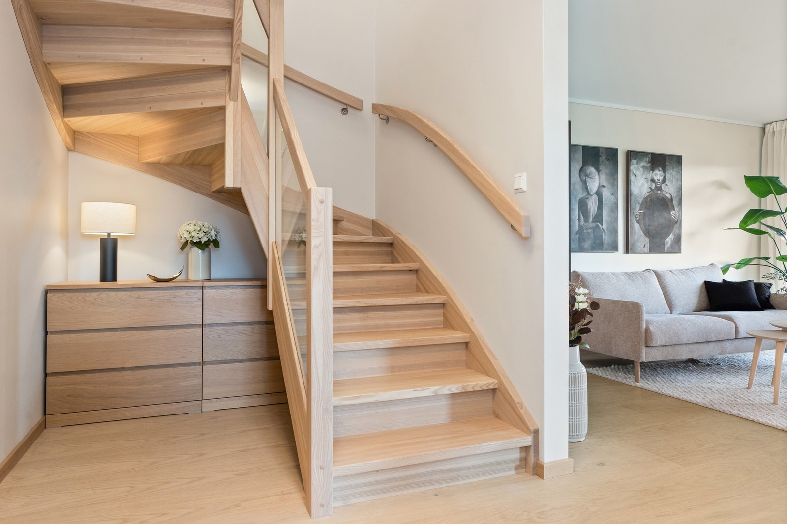 Trappen opp til andre etasje er som et smykke i boligen med lyst tre og et glassrekkverk som gir et åpent og stilig inntrykk. Galleribilde