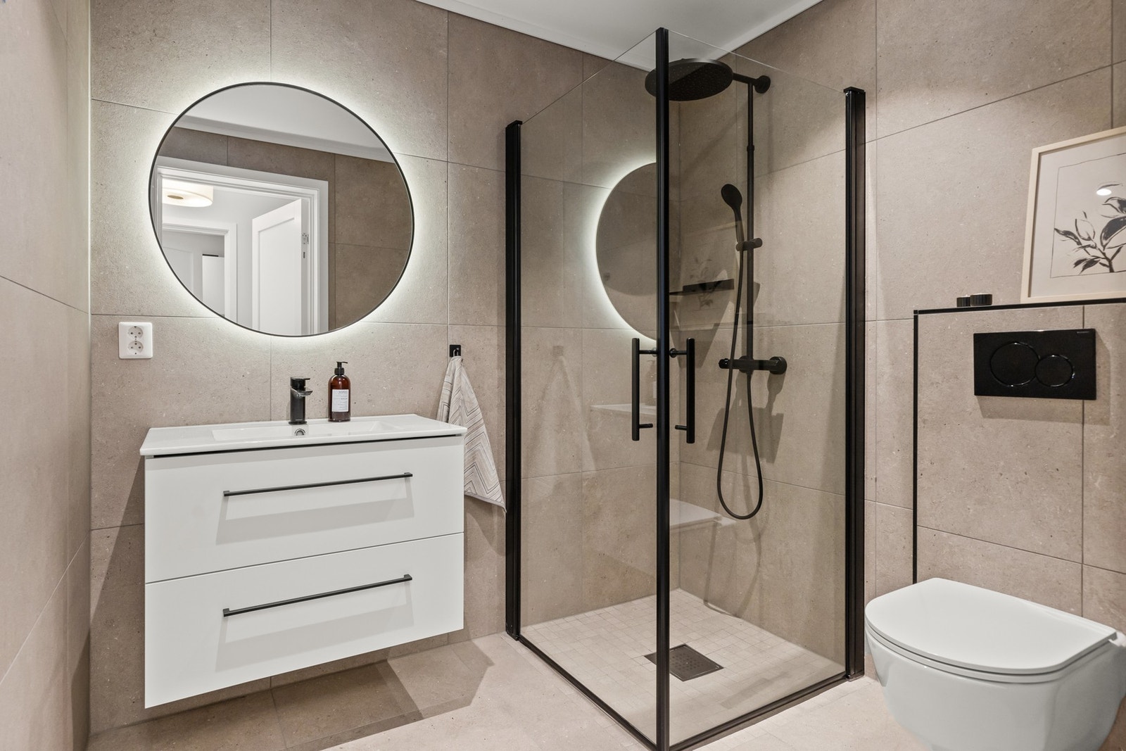 Badet i første etasje er stilfullt og delikat med tidsriktige flisvalg, sminkelys i speil og tøffe svarte detaljer. Galleribilde