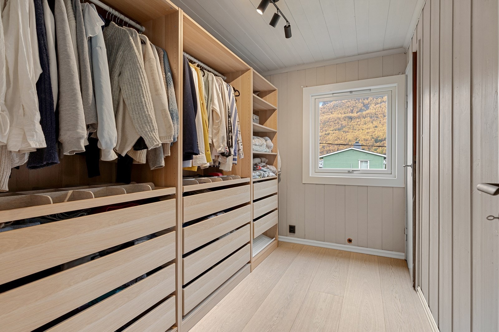 Soverom nytta som walk-in garderobe, der det også er oppbevaringsmoglegheiter over trappeløp. Galleribilde