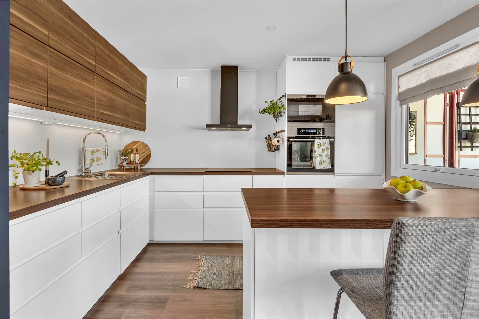 IKEA Kjøkkeninnredning fra 2016 i følge selger, med slette fronter, halvøy, benkeplater av laminat, malt flate mellom kjøkkenbenk og overskap samt Integrerte hvitevarer. Galleribilde