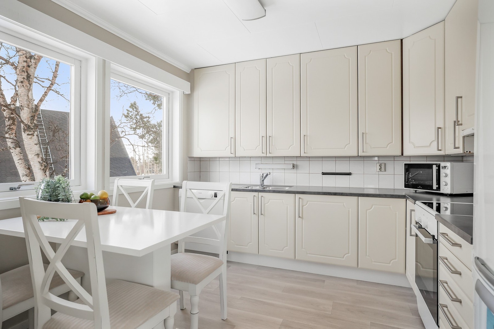 Kjøkkenet har en lys innredning med profilerte fronter og benkeplate av laminat. Galleribilde