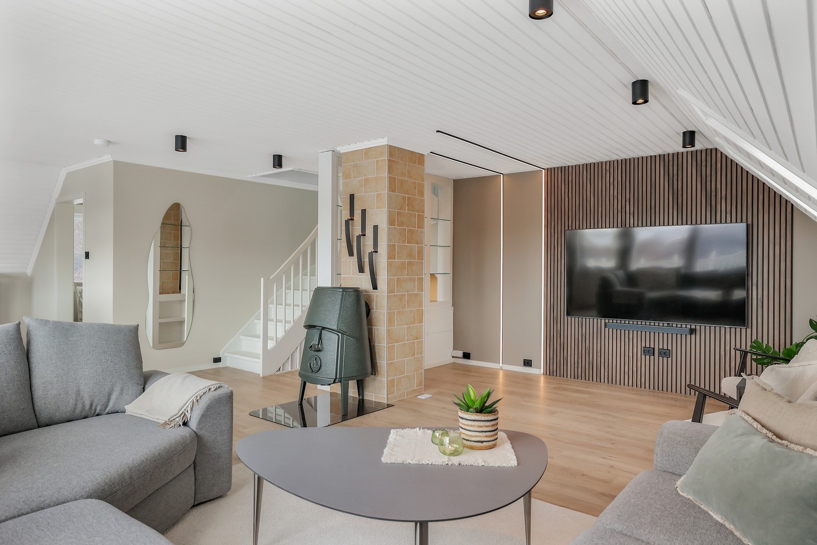 Stuen er malt i tidløse farger og har en moderne preg med spilevegg og ledstriper. Galleribilde