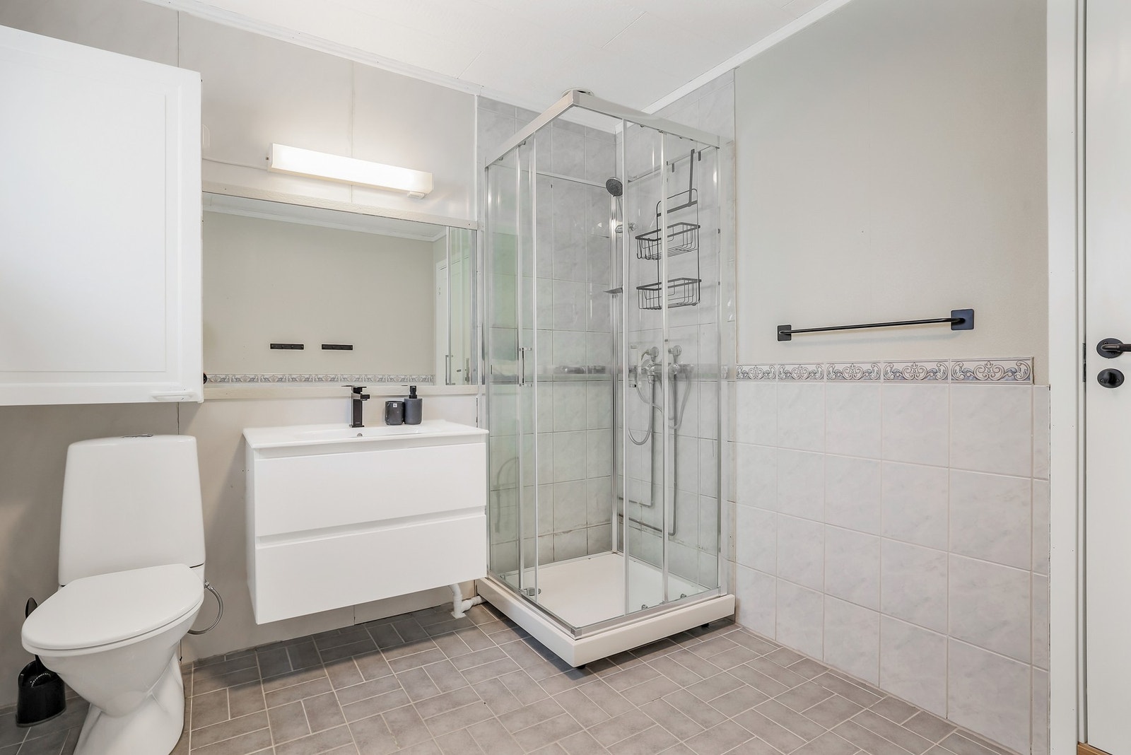 Badet har flislagt gulv med gulvvarme, og fliser og baderomsplater på veggene. Galleribilde